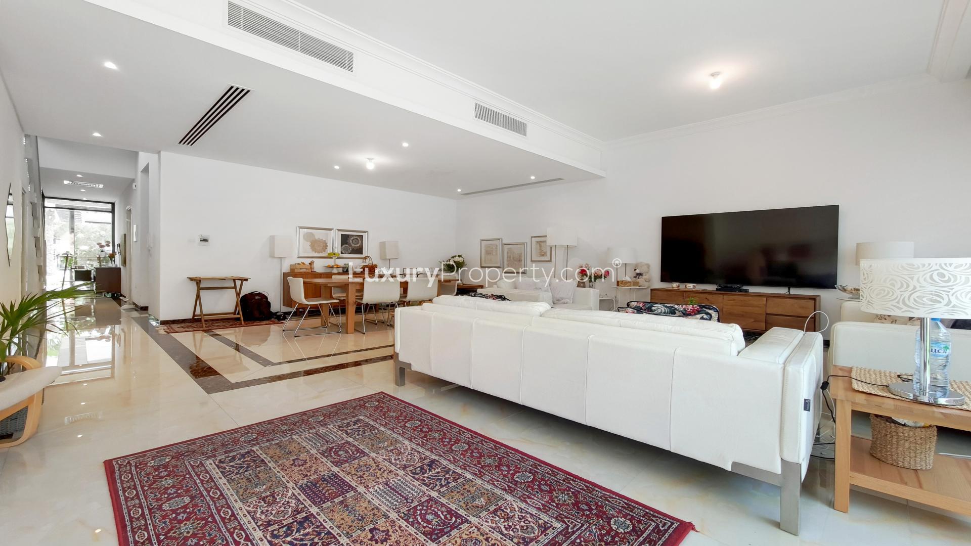 Bright living area in 3-bedroom townhouse, Damac Hills, with garden view and modern decor