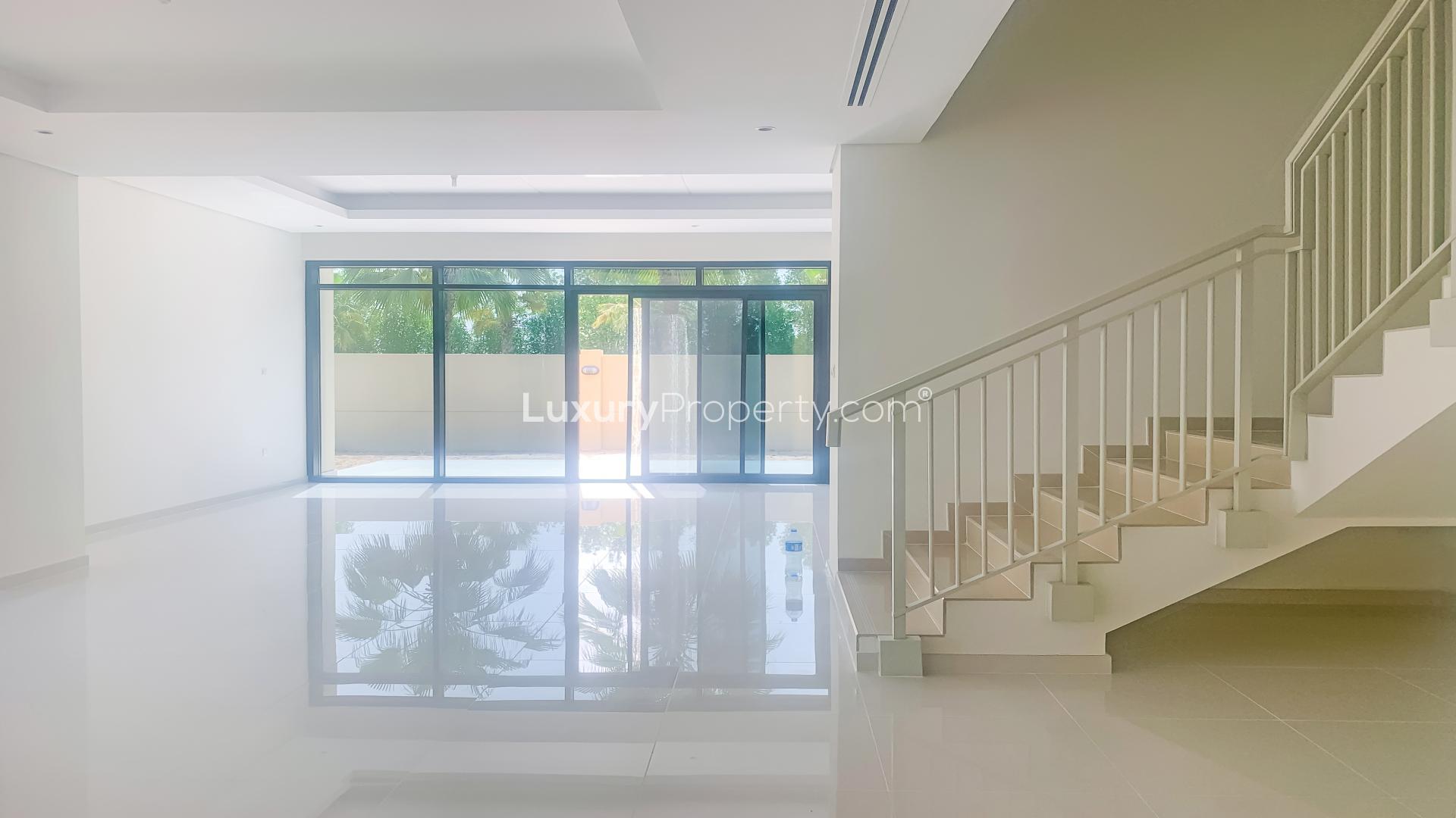 Spacious living area with staircase in Damac Hills townhouse, Queens Meadow, for rent