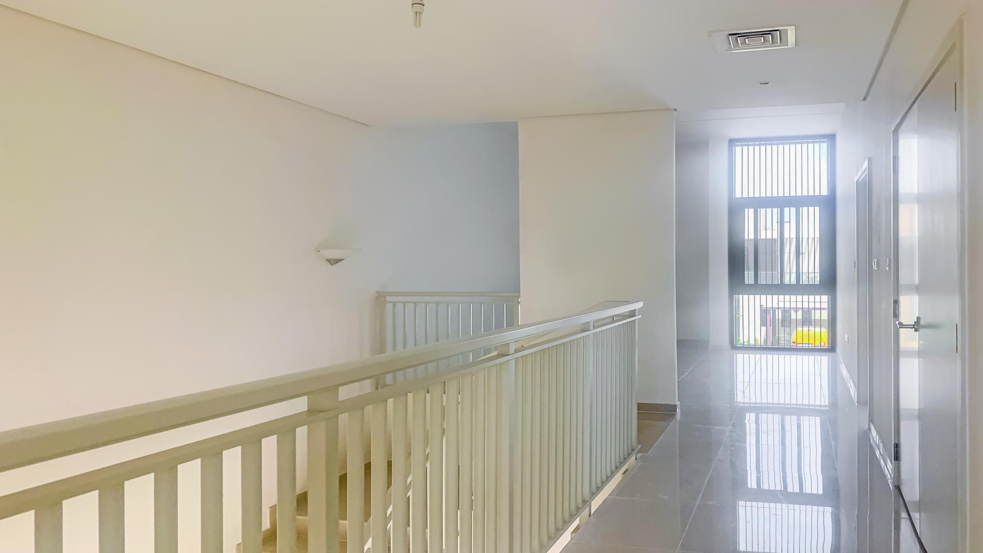 "Bright hallway with modern railing in Damac Hills townhouse, Queens Meadow, available for rent.",Modern bathroom in three-bedroom townhouse, Damac Hills, Queens Meadow, featuring sleek fixtures and tiles