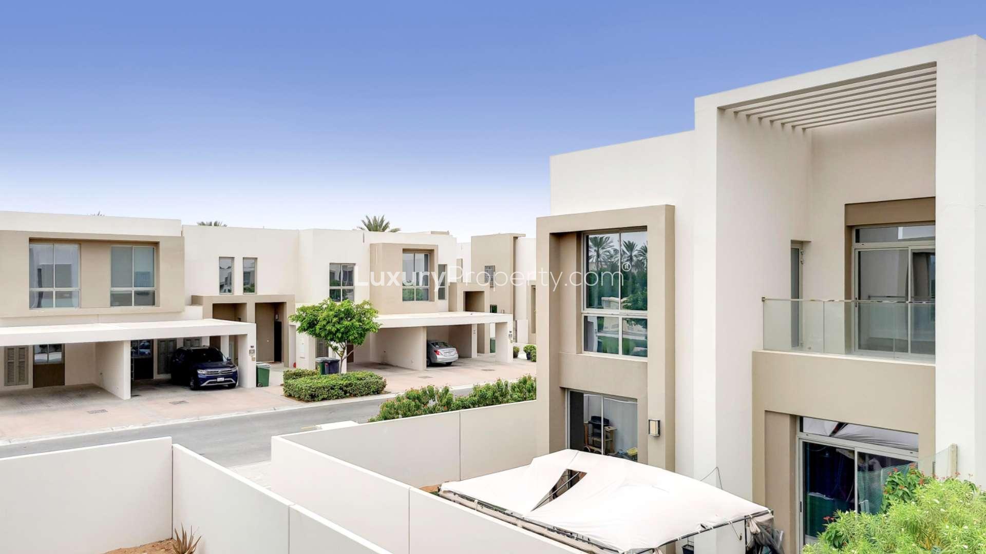"Spacious backyard of 3-bed townhouse in Reem Community, Arabian Ranches 2, for rent.","Modern 3-bedroom townhouse exterior in Reem Community, Arabian Ranches 2, available for rent.",Empty living room in 3-bed townhouse, Arabian Ranches 2 Reem Community, for rent