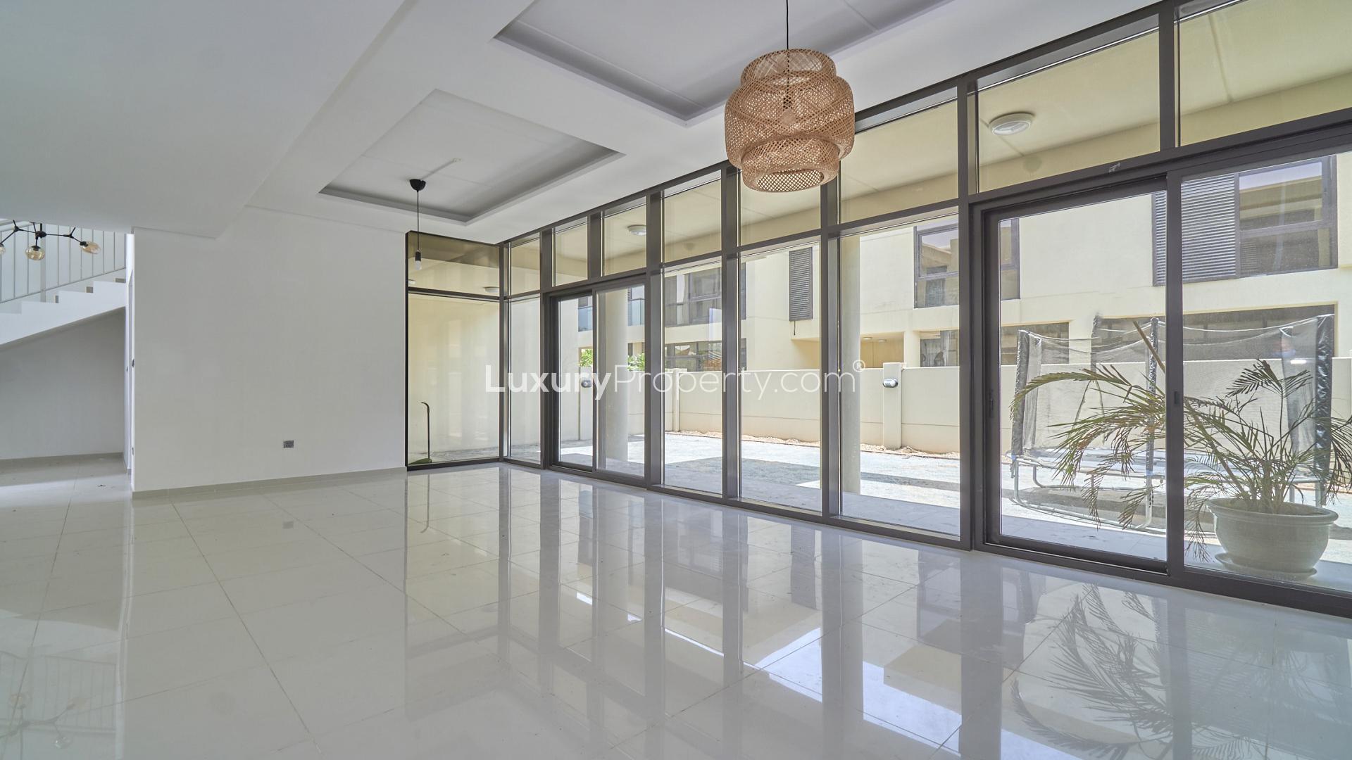 Modern townhouse exterior with landscaped garden in Rockwood, Damac Hills, available for rent