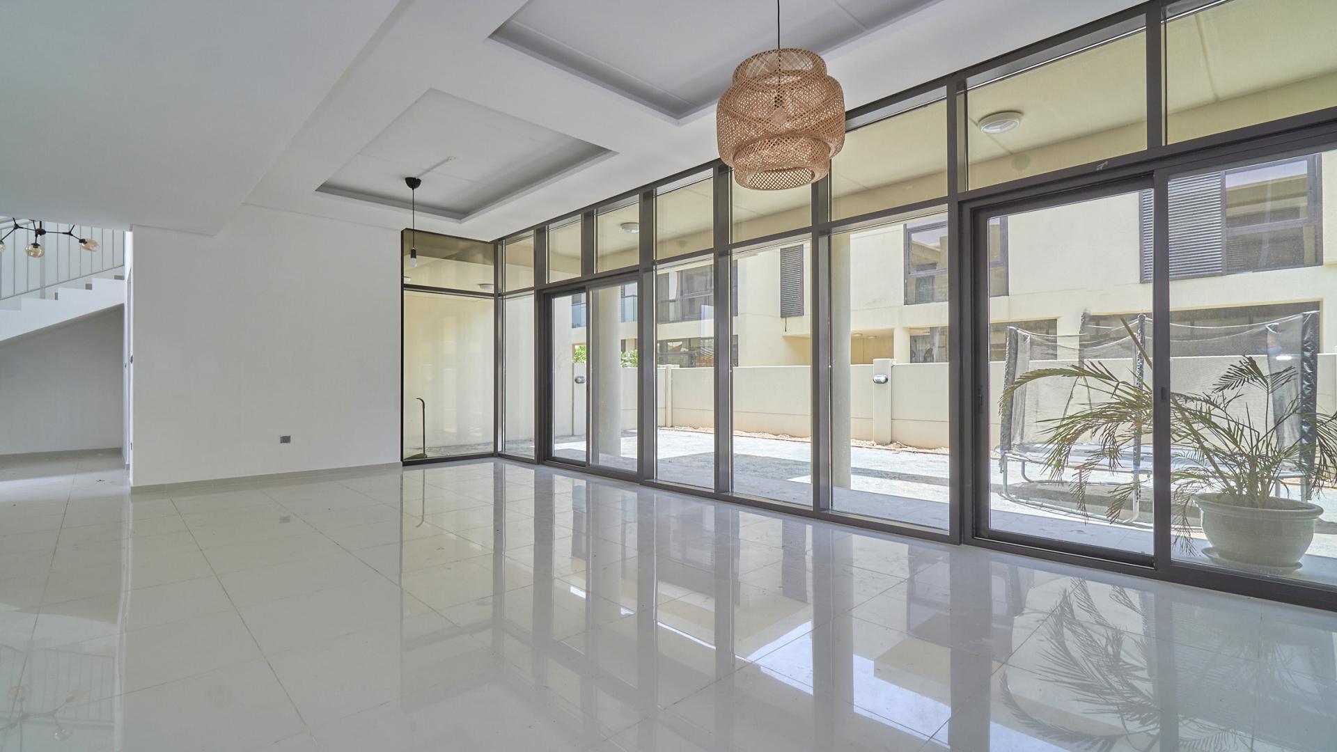 Modern townhouse exterior with landscaped garden in Rockwood, Damac Hills, available for rent