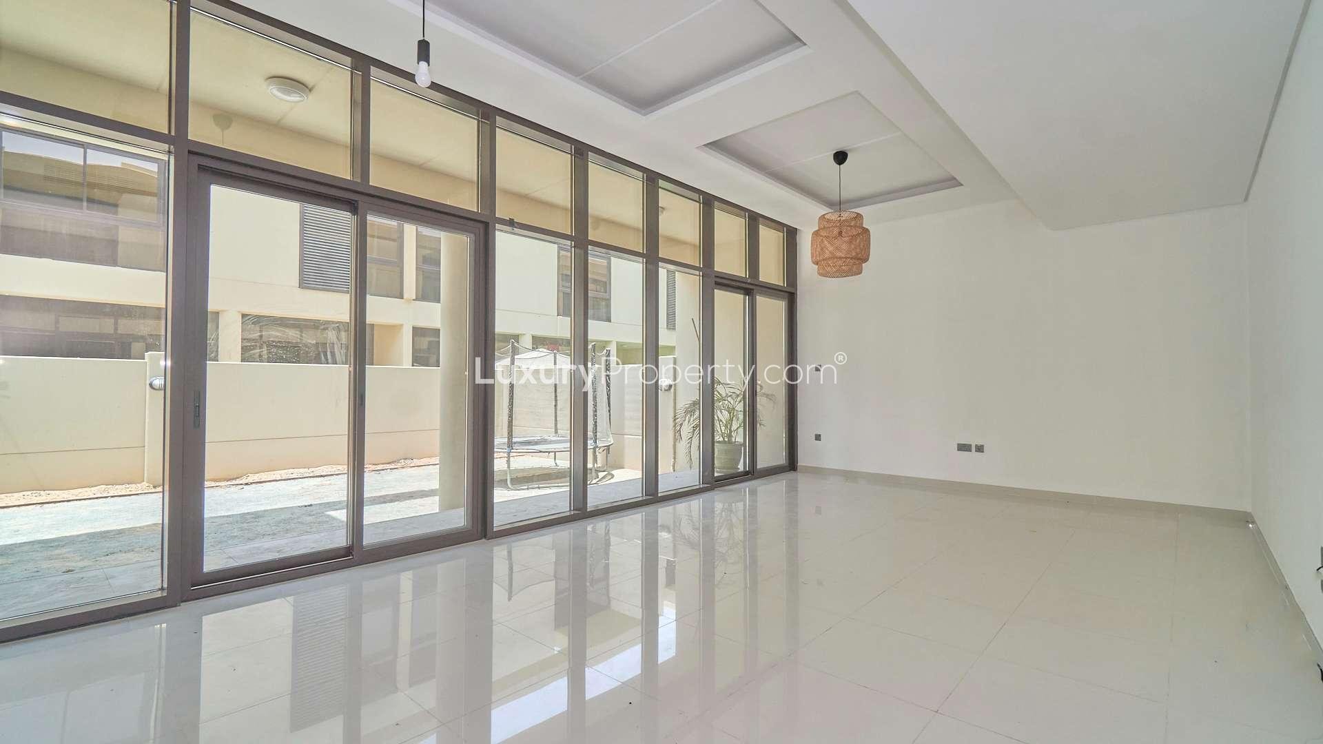 N/A,Spacious living room with floor-to-ceiling windows in Damac Hills townhouse for rent