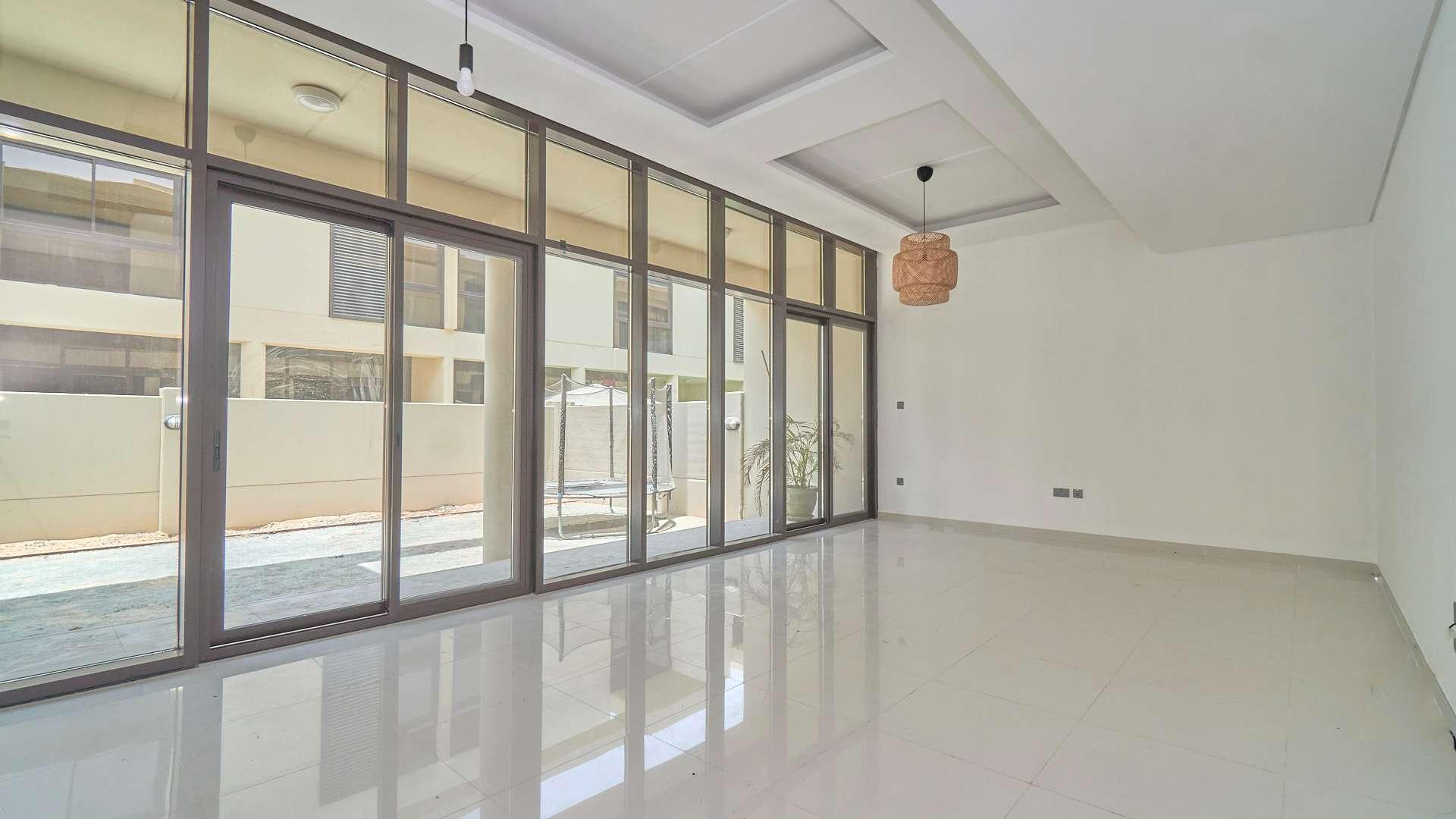 N/A,Spacious living room with floor-to-ceiling windows in Damac Hills townhouse for rent