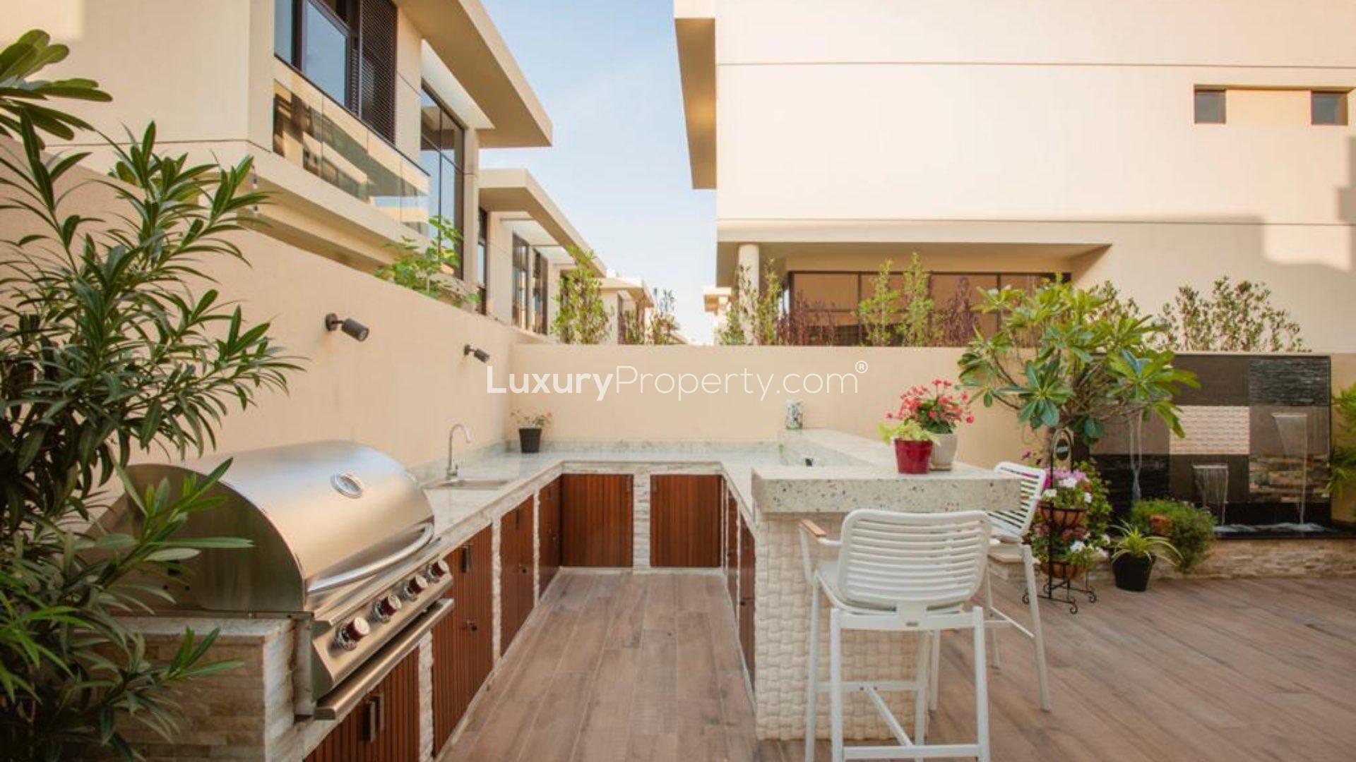 Upgraded garden with seating in furnished Damac Hills townhouse, Rochester community, for rent