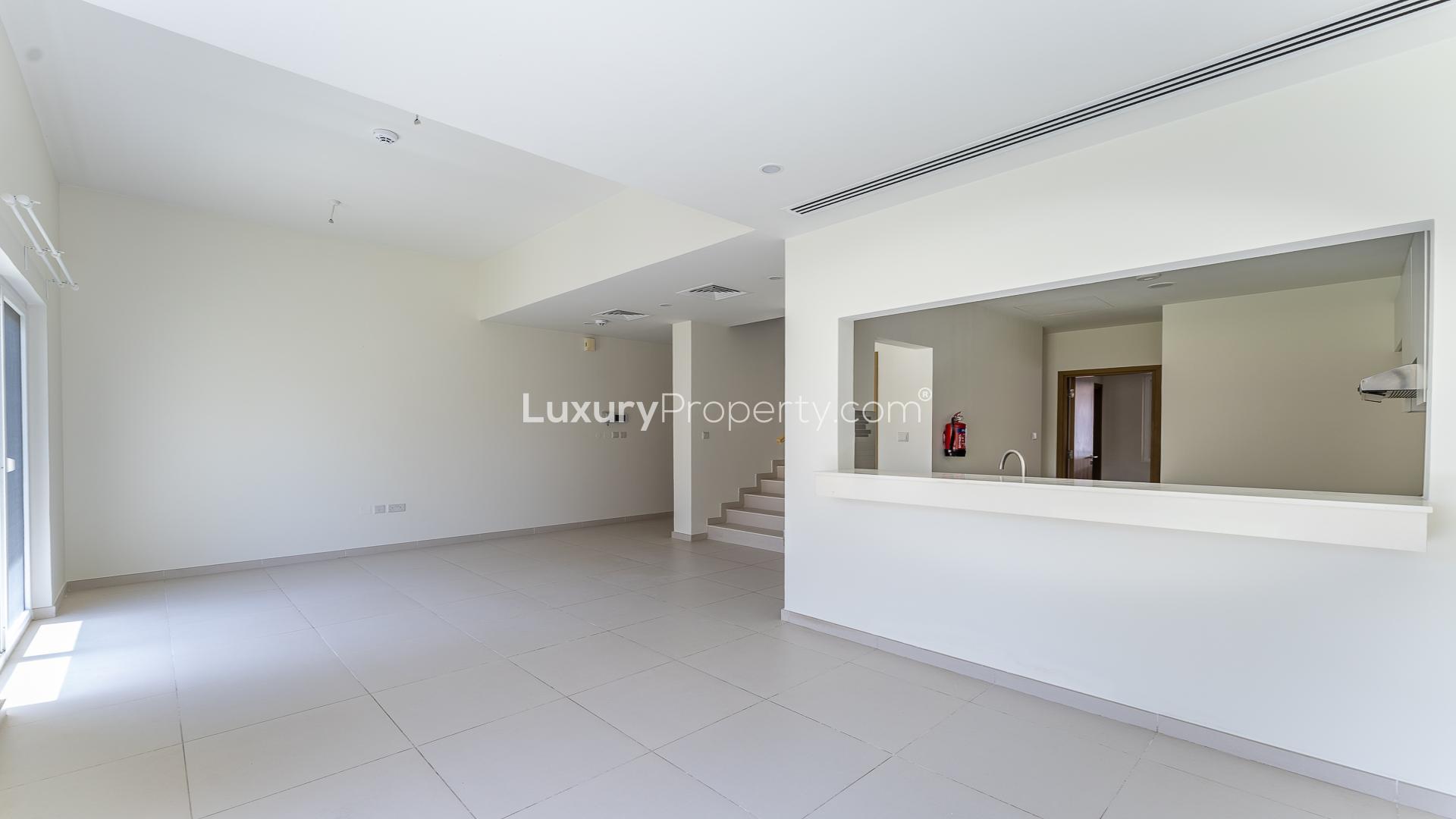 Bright living room in Amaranta townhouse, Villanova, with garden view through sliding doors