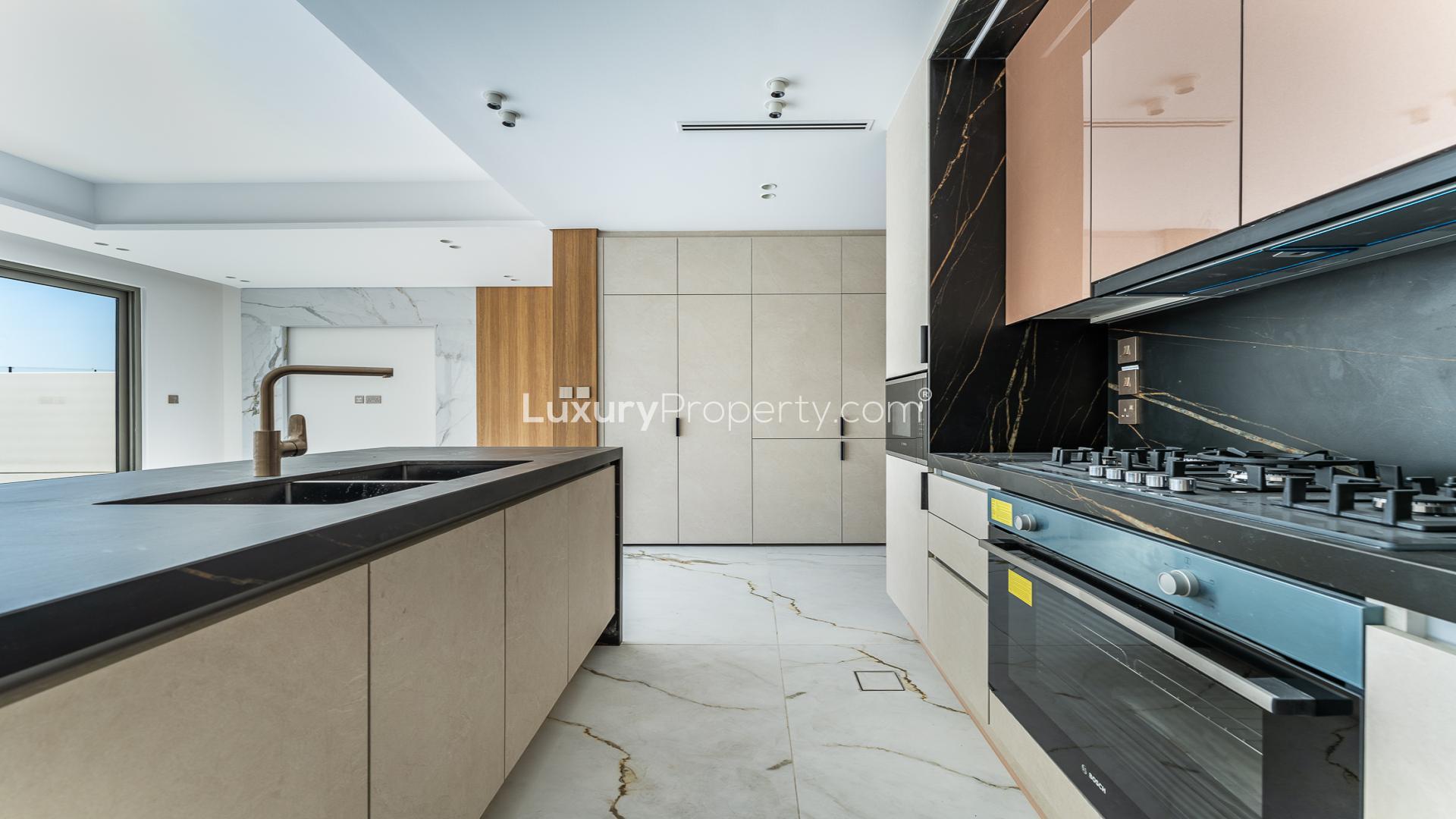 Modern kitchen interior in 3-bedroom townhouse, Jasmine Lane, Jumeirah Golf Estates, marble and wood finishes