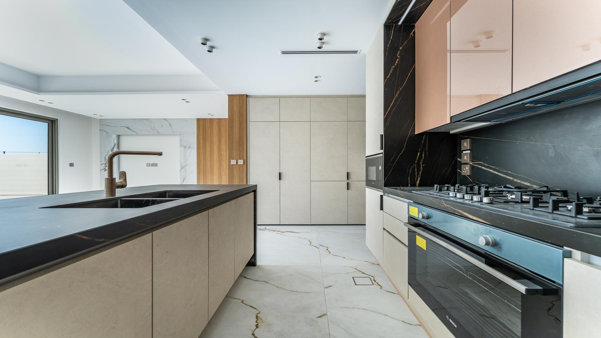 Modern kitchen interior in 3-bedroom townhouse, Jasmine Lane, Jumeirah Golf Estates, marble and wood finishes