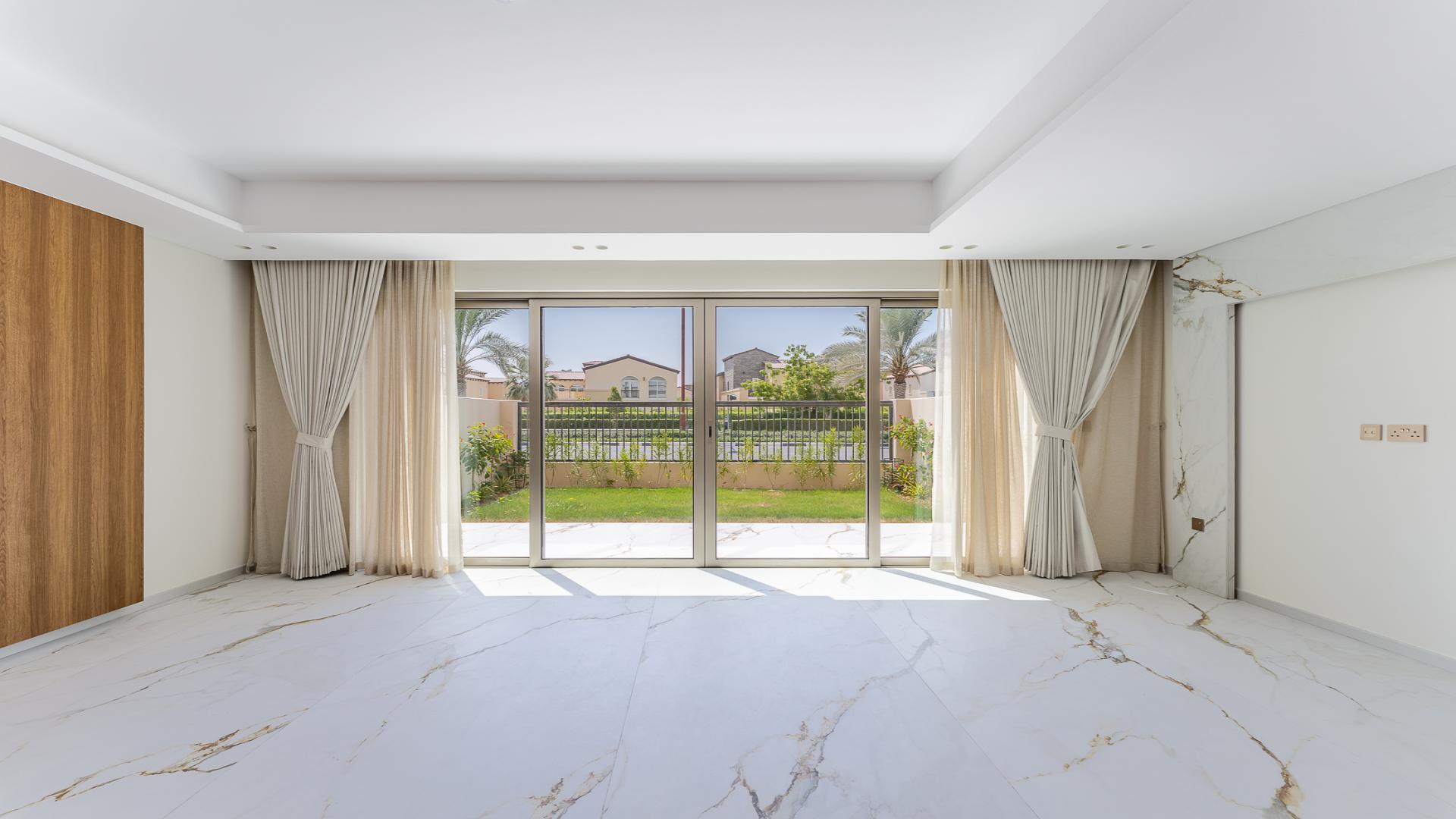 Exterior view of Jasmine Lane townhouse with patio and garden in Jumeirah Golf Estates