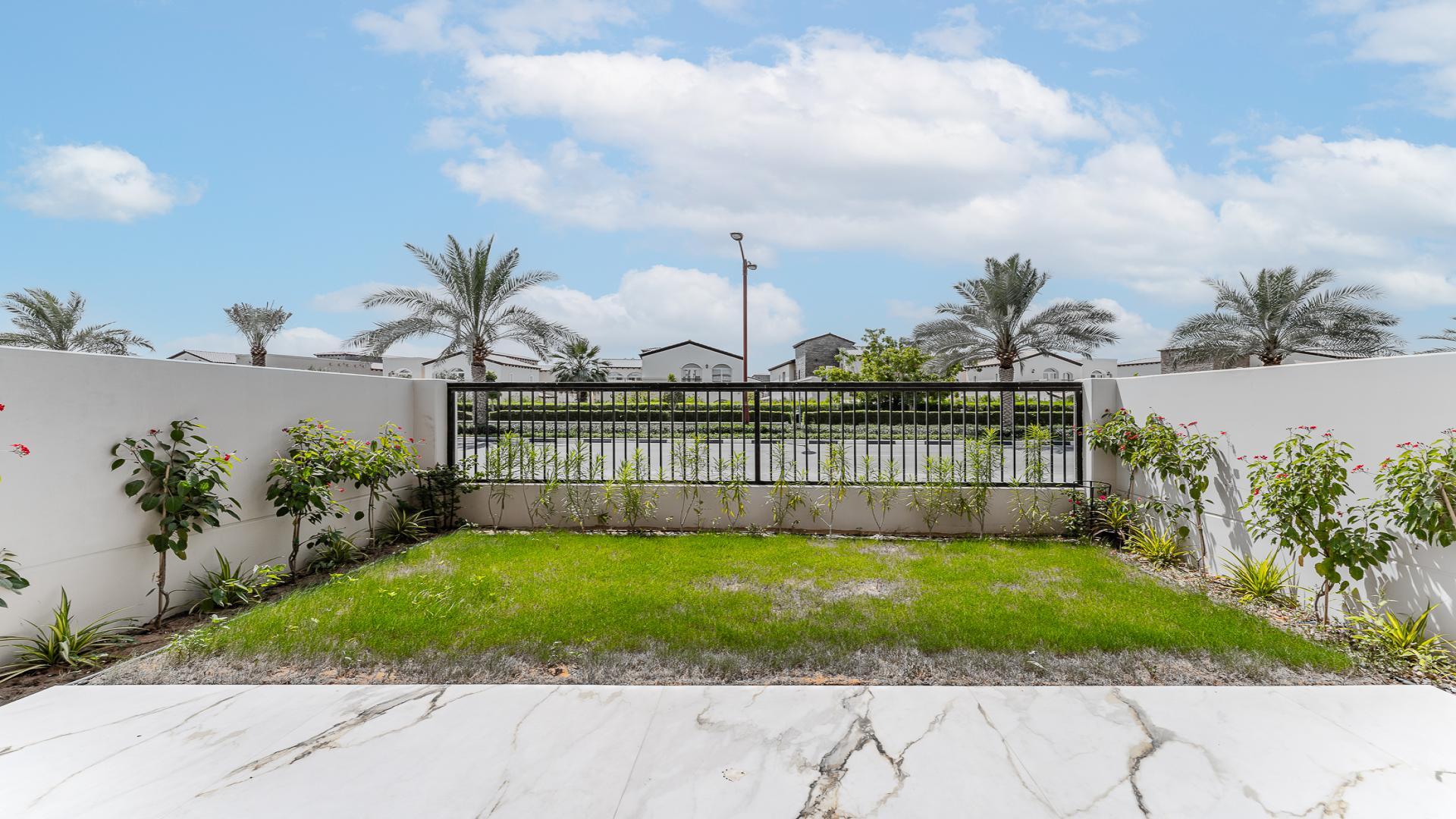 Bright living room with marble floors and garden view in Jasmine Lane townhouse, Jumeirah Golf Estates