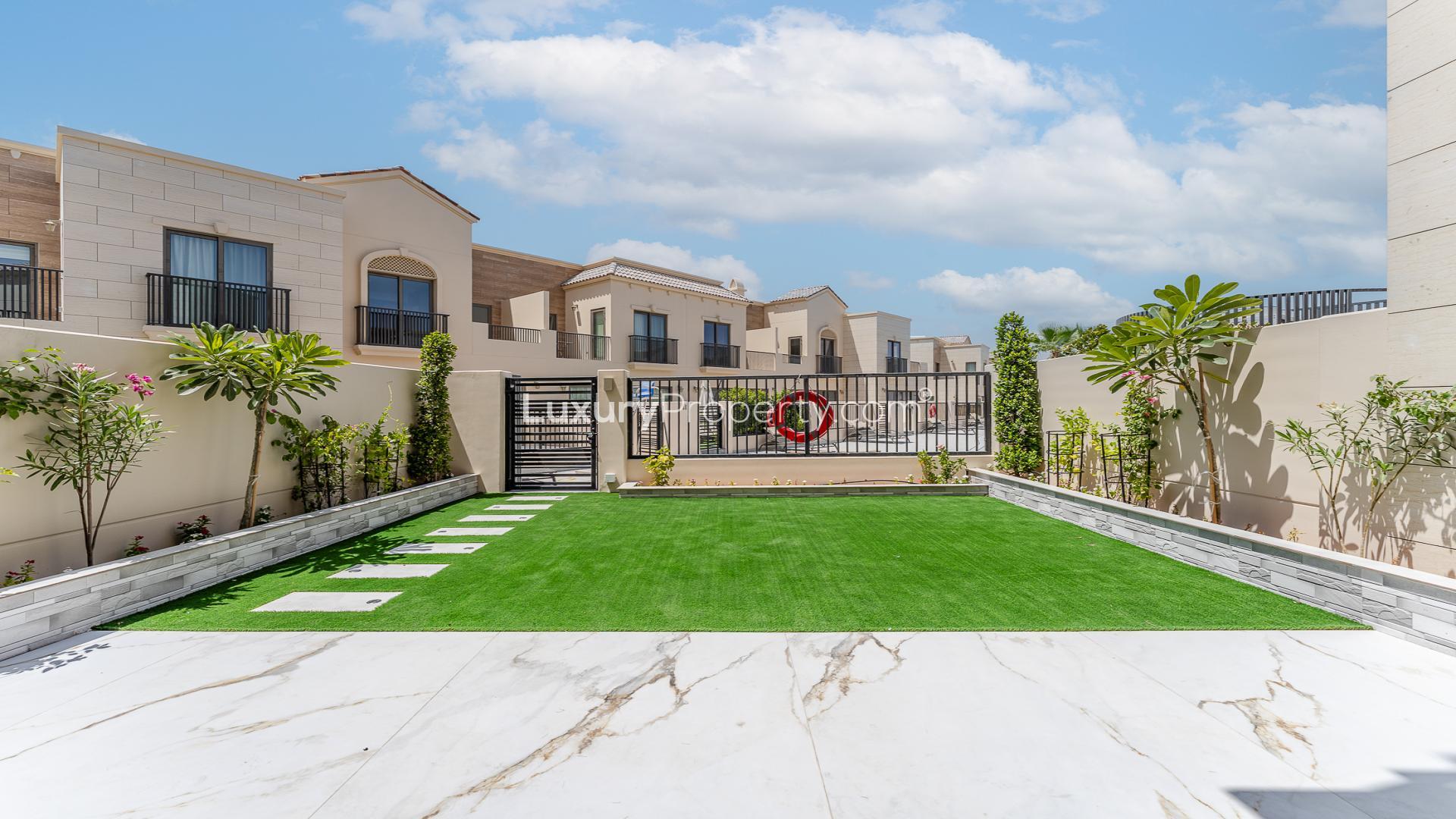 "Modern kitchen with island and garden view in Jumeirah Golf Estates townhouse, Jasmine Lane.","Modern townhouse exterior with landscaped garden in Jumeirah Golf Estates, Jasmine Lane for rent.",Modern kitchen with marble flooring in Jumeirah Golf Estates townhouse, Jasmine Lane