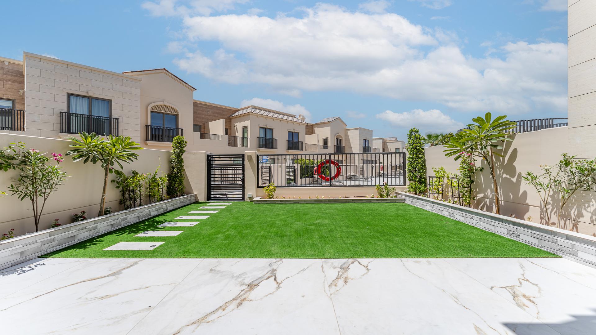 "Modern kitchen with island and garden view in Jumeirah Golf Estates townhouse, Jasmine Lane.","Modern townhouse exterior with landscaped garden in Jumeirah Golf Estates, Jasmine Lane for rent.",Modern kitchen with marble flooring in Jumeirah Golf Estates townhouse, Jasmine Lane