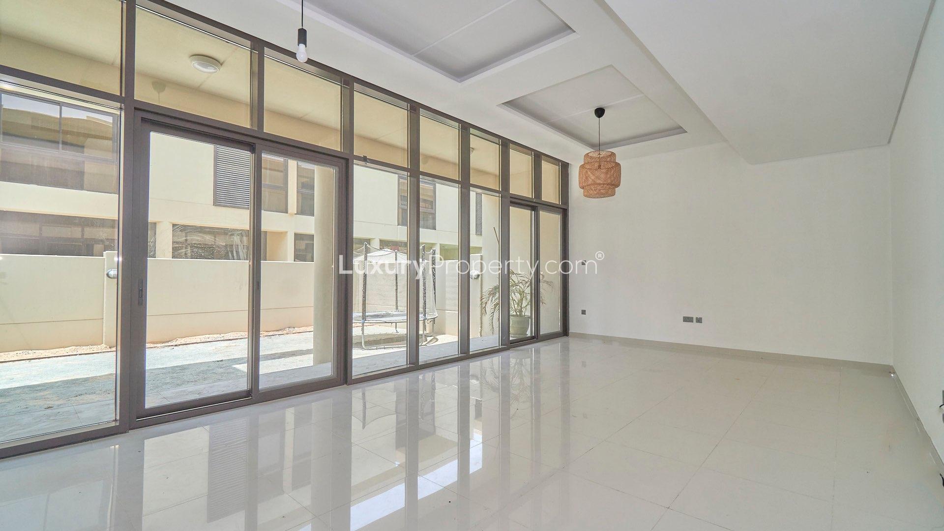 Bright living area with large windows in Trinity townhouse, Damac Hills