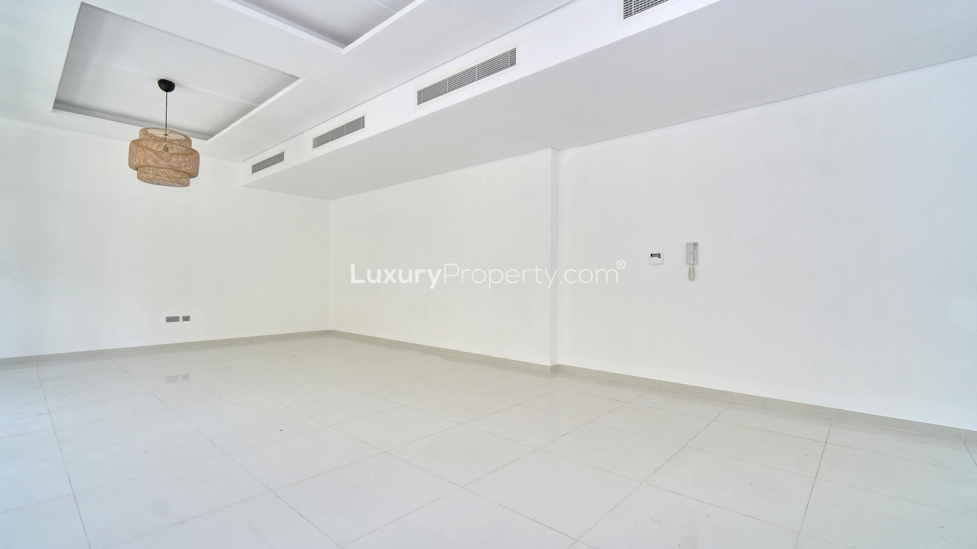 "Spacious living area in 3-bedroom townhouse, Trinity, Damac Hills, with modern design and natural light.",Empty living room in 3-bedroom townhouse, Trinity, Damac Hills with modern ceiling design