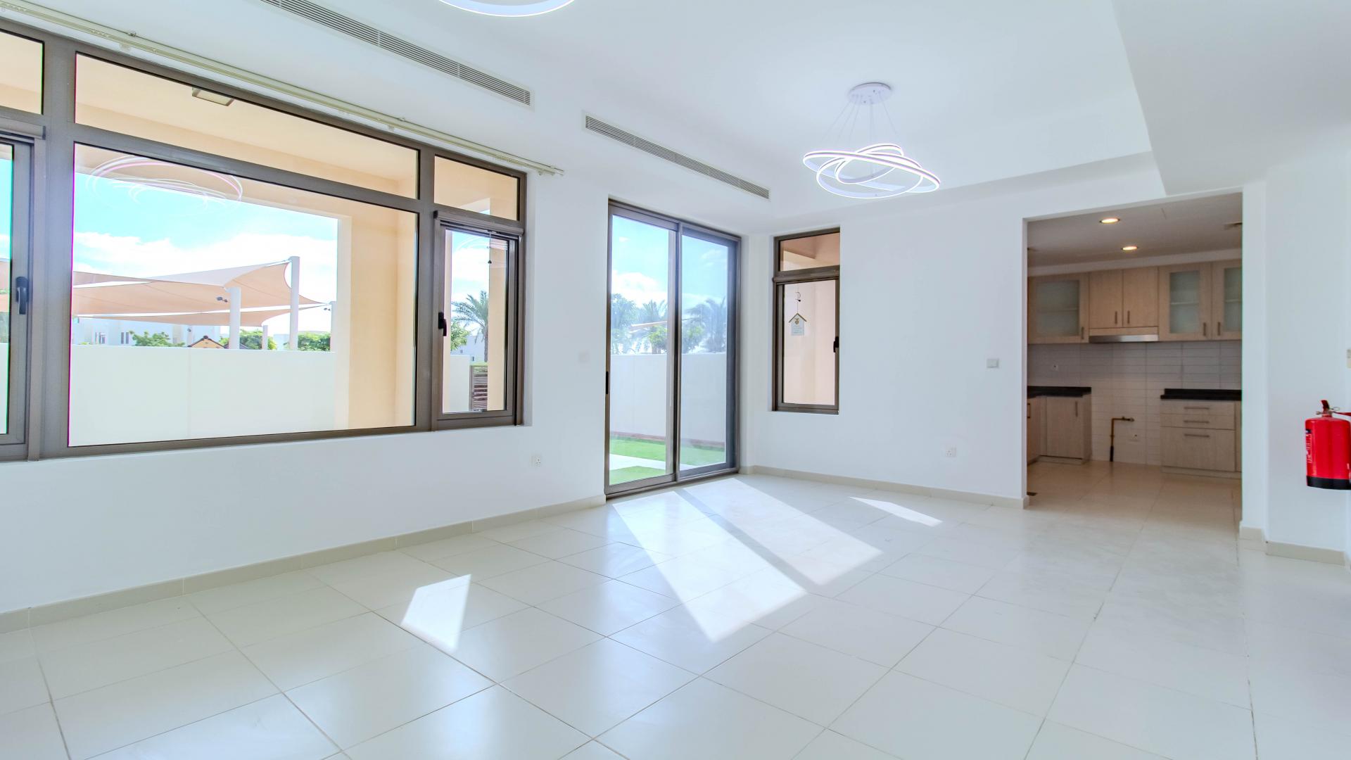 Lush green backyard of Mira Oasis townhouse, featuring spacious lawn and clear blue sky