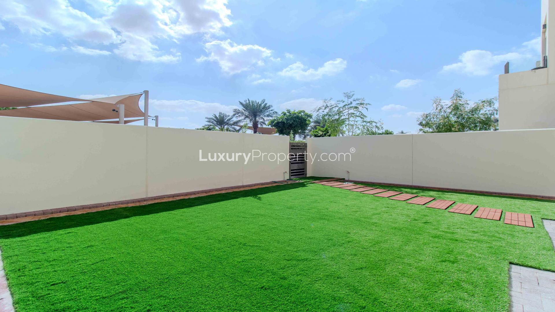 Bright living room in Mira Oasis townhouse with large windows and garden view