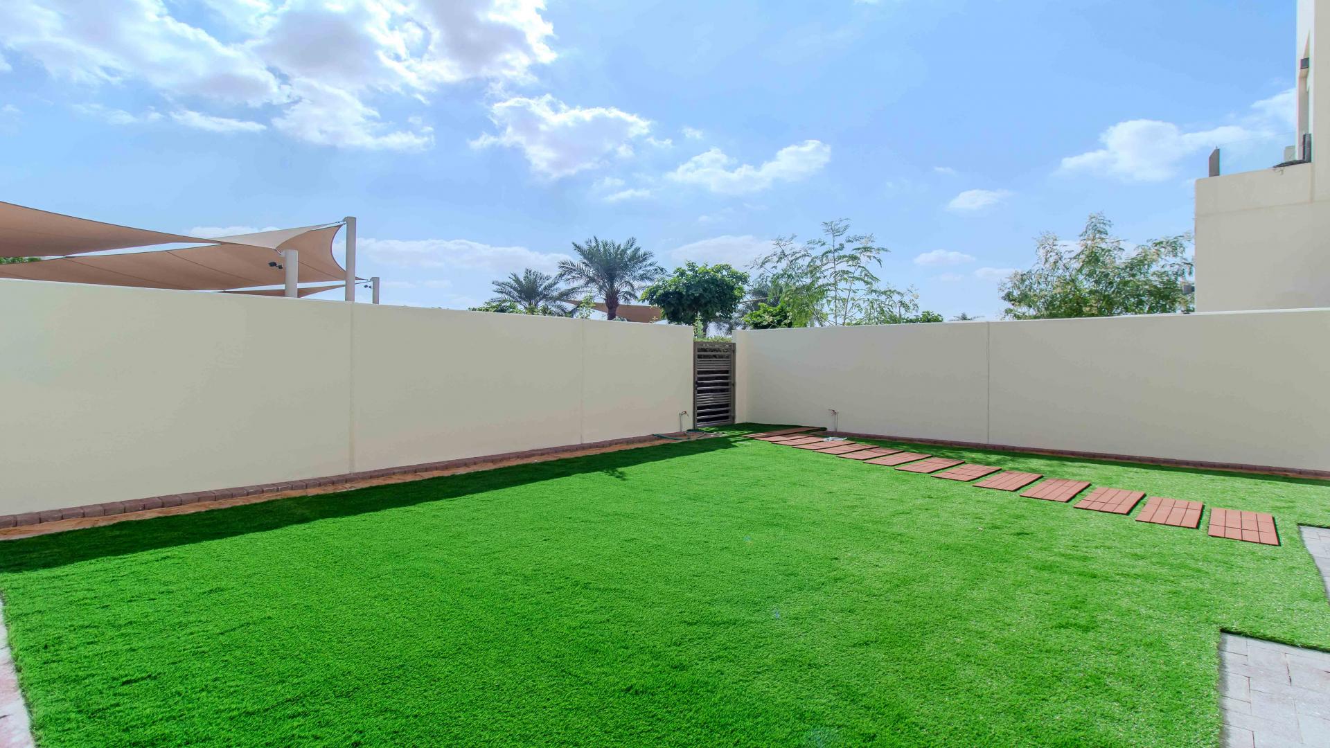 Bright living room in Mira Oasis townhouse with large windows and garden view