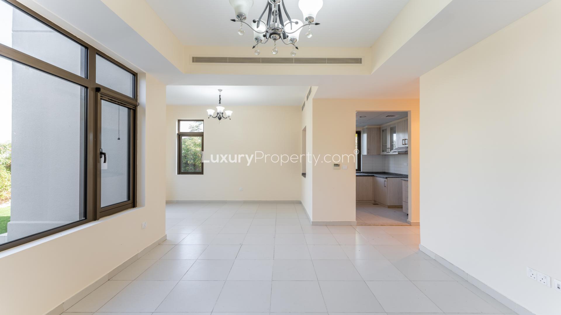 Bright living room with large windows in Mira Oasis townhouse, overlooking lush park greenery