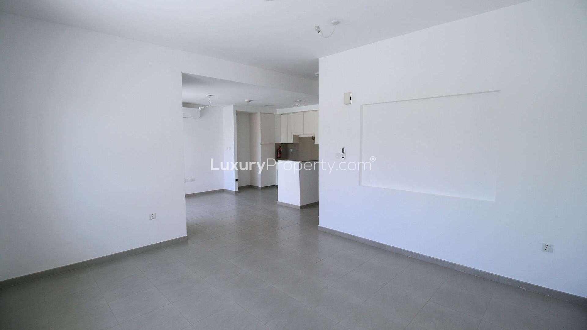 Modern living room with large glass doors in Zahra Townhouse, Town Square Dubai