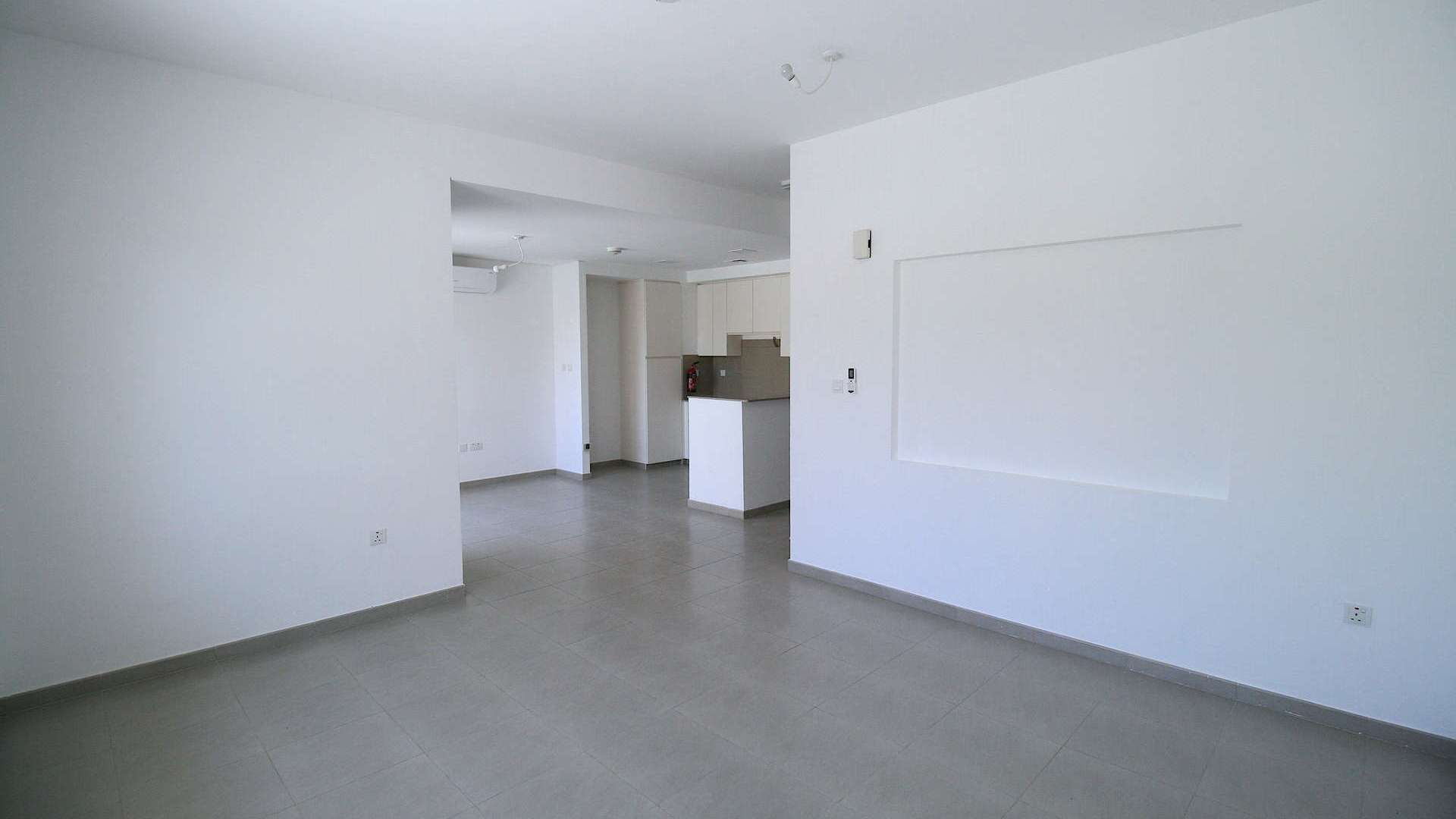 Modern living room with large glass doors in Zahra Townhouse, Town Square Dubai