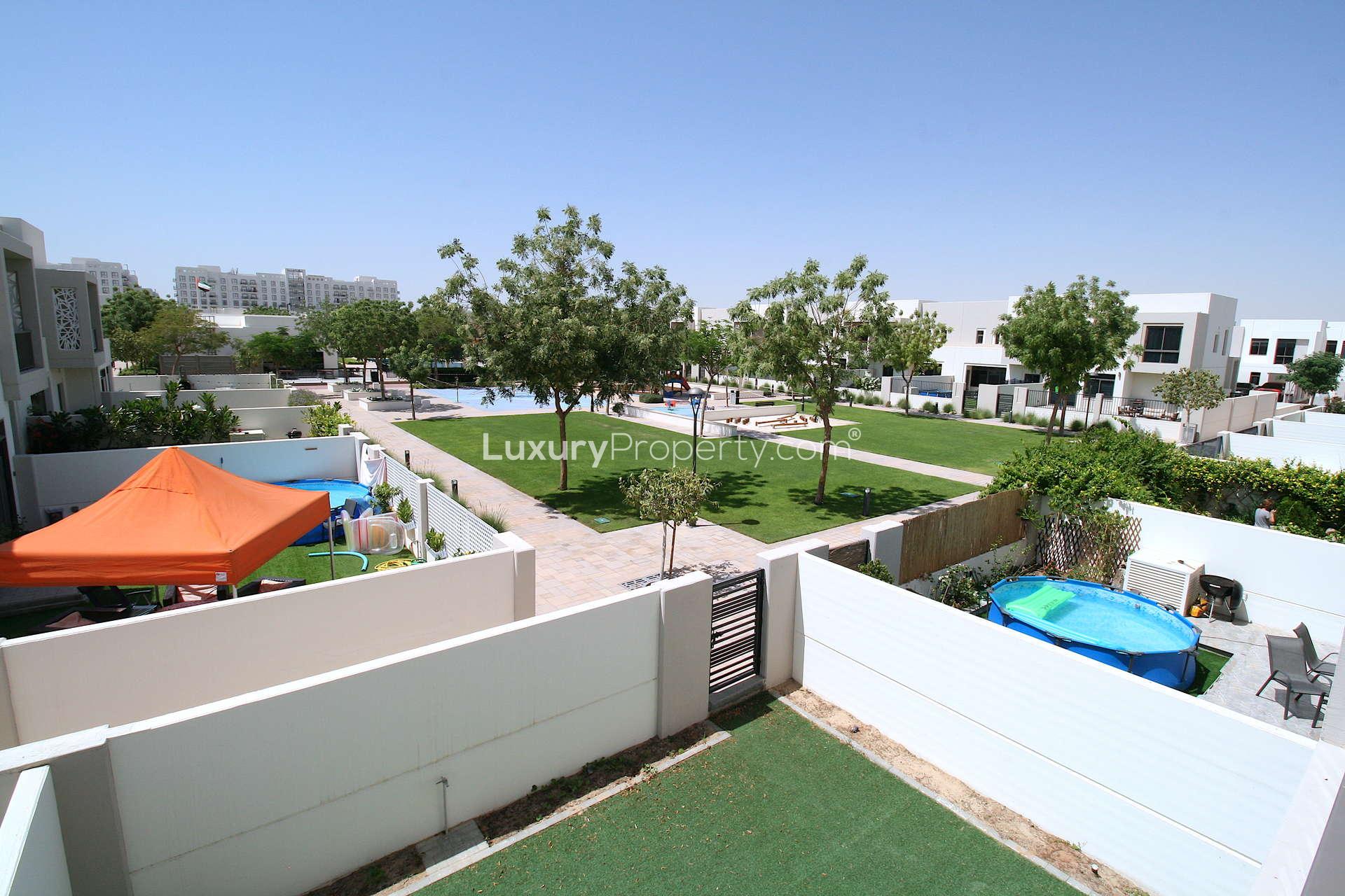 Balcony view of lush green park in Zahra Townhouses, Town Square, Al Zahra