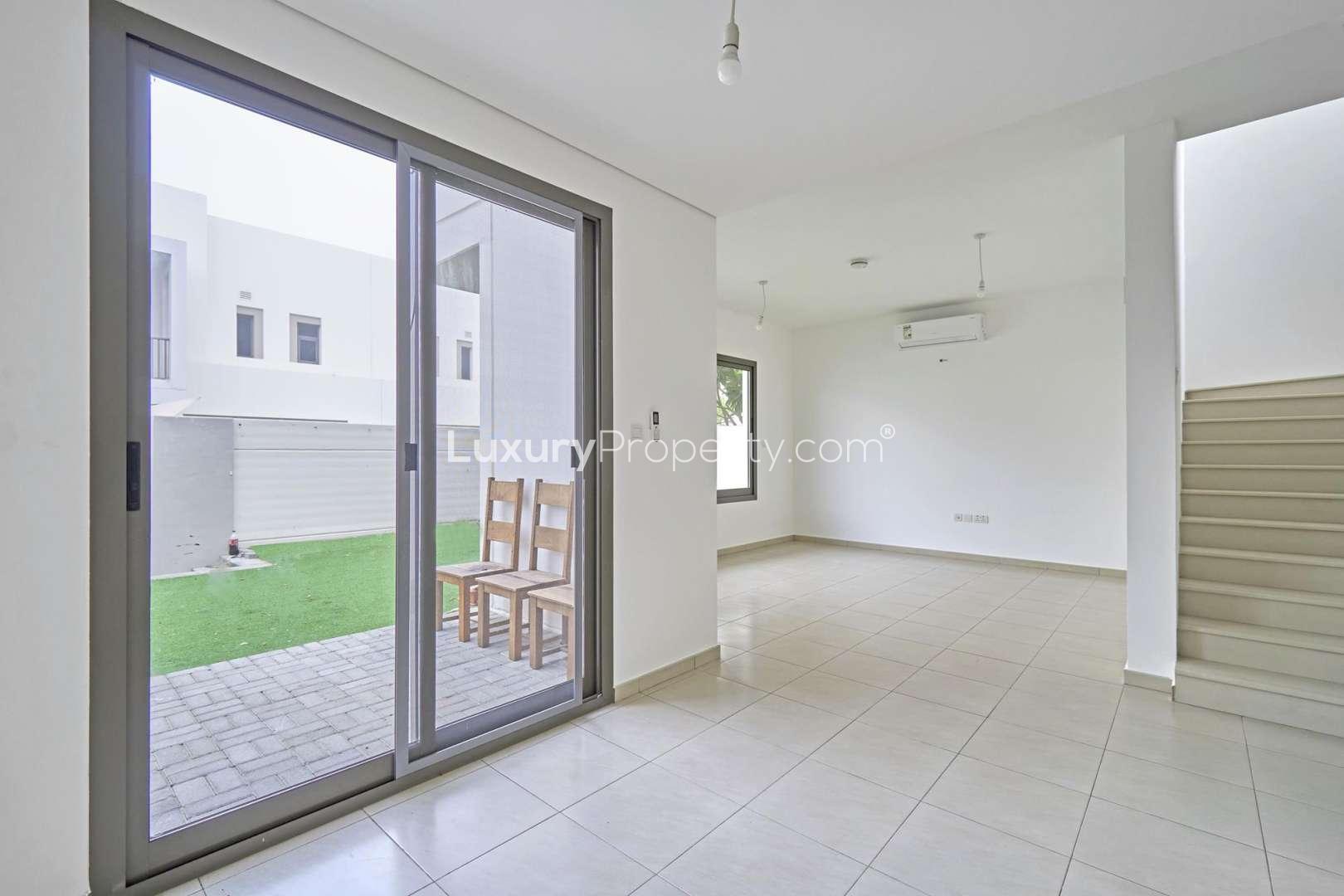Empty living area in Zahra Townhouse, Town Square, with modern tiled flooring and open layout