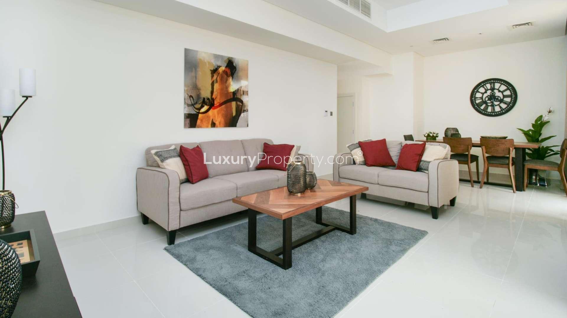 Dining area in 3-bedroom townhouse, Zinnia, Damac Hills 2, with modern decor and wall clock