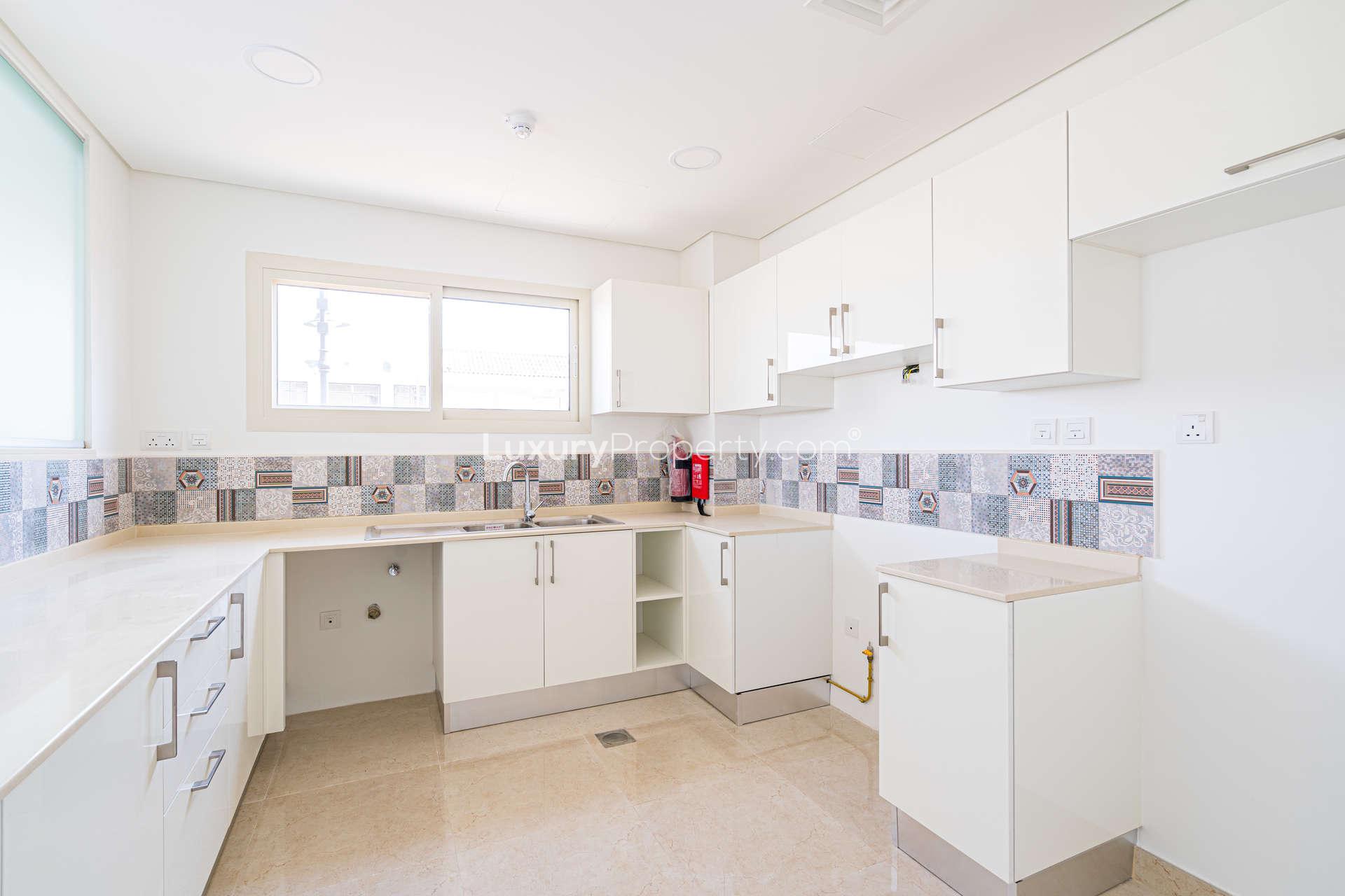 Modern kitchen in 3-bedroom townhouse, Al Andalus, Jumeirah Golf Estates, with stylish tile backsplash