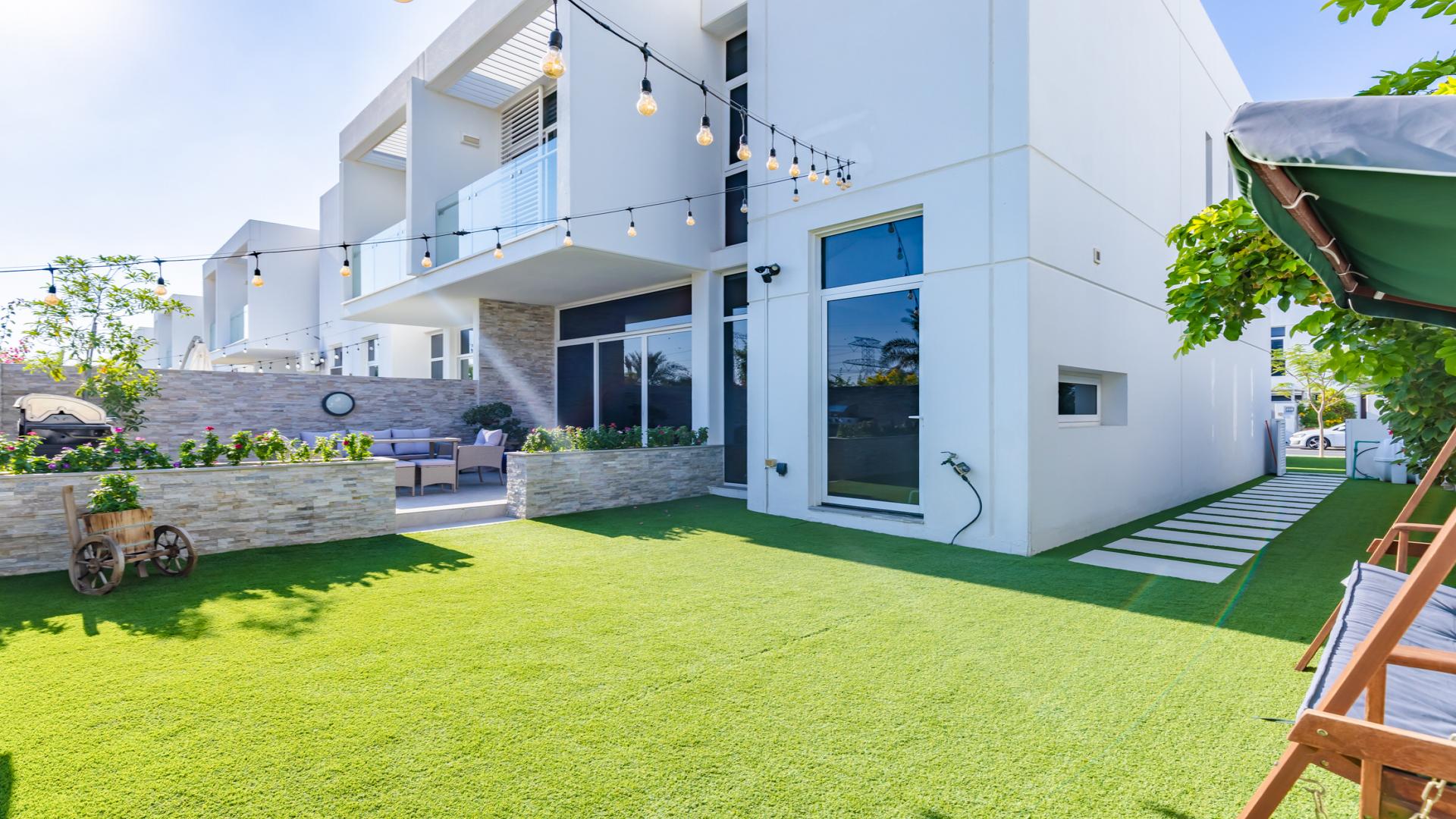 Modern living room in Arabella Townhouse, featuring blue sofa and stylish dining area