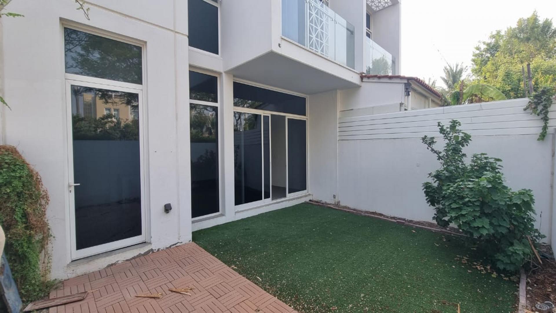 Townhouse community view in Arabella 3, Mudon, featuring palm trees and modern architecture