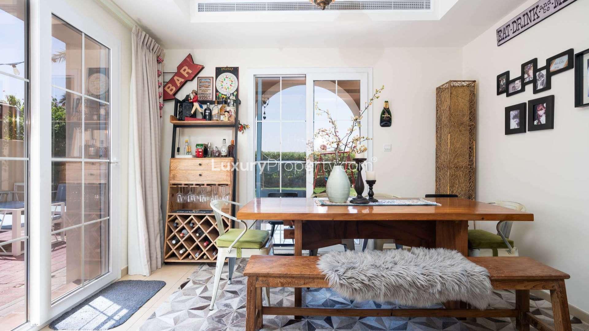 Dining area in 3-bedroom villa, featuring wooden table and wine rack, Alma townhouse