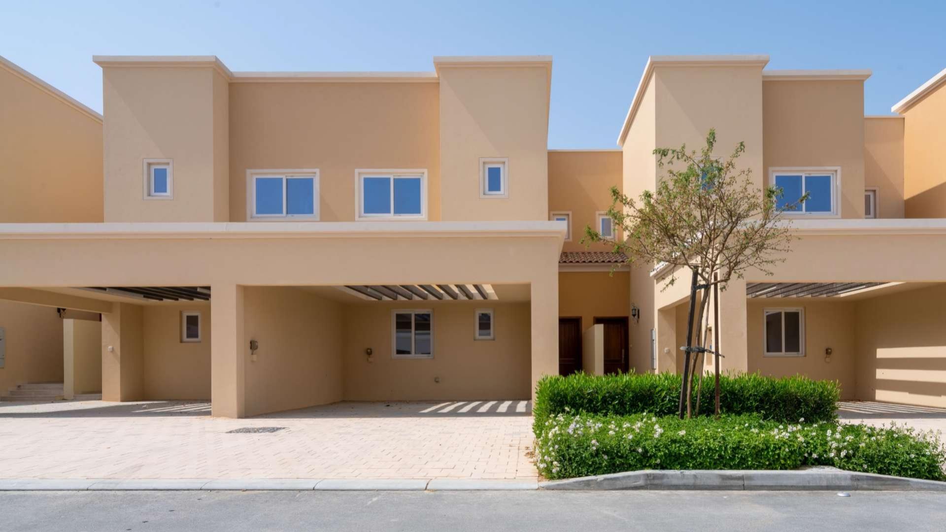 Single row townhouse exterior in Villanova, Dubai Land, with driveway and garden