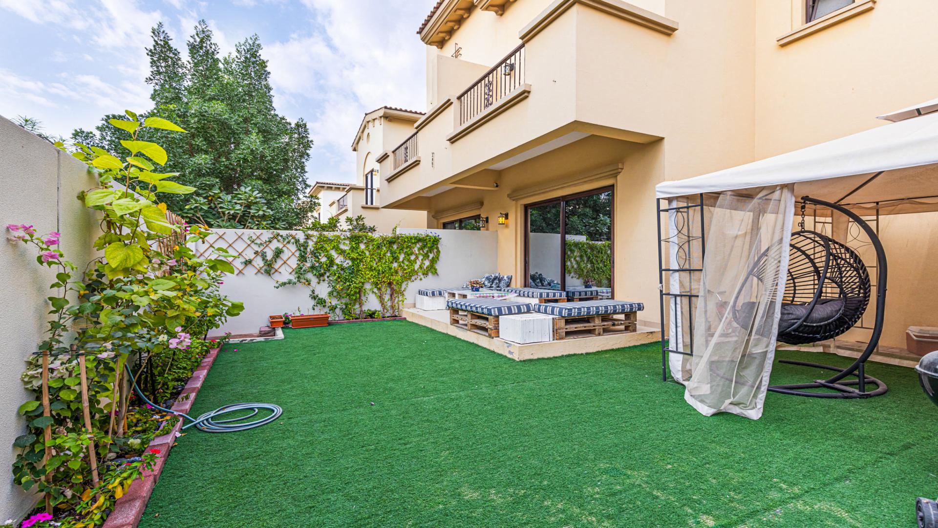 Modern living room in well-maintained Mira townhouse, featuring cozy seating and garden view