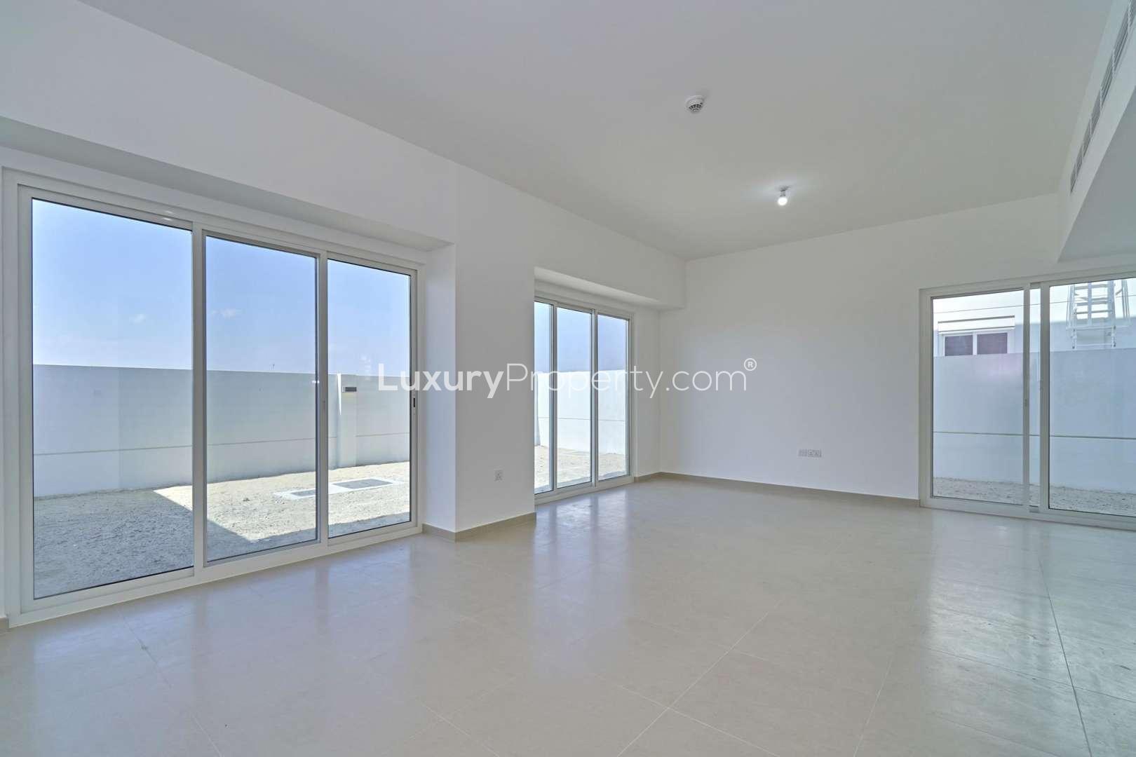 Spacious living area in Arabella Townhouses, Mudon; modern design, large windows, tiled floors