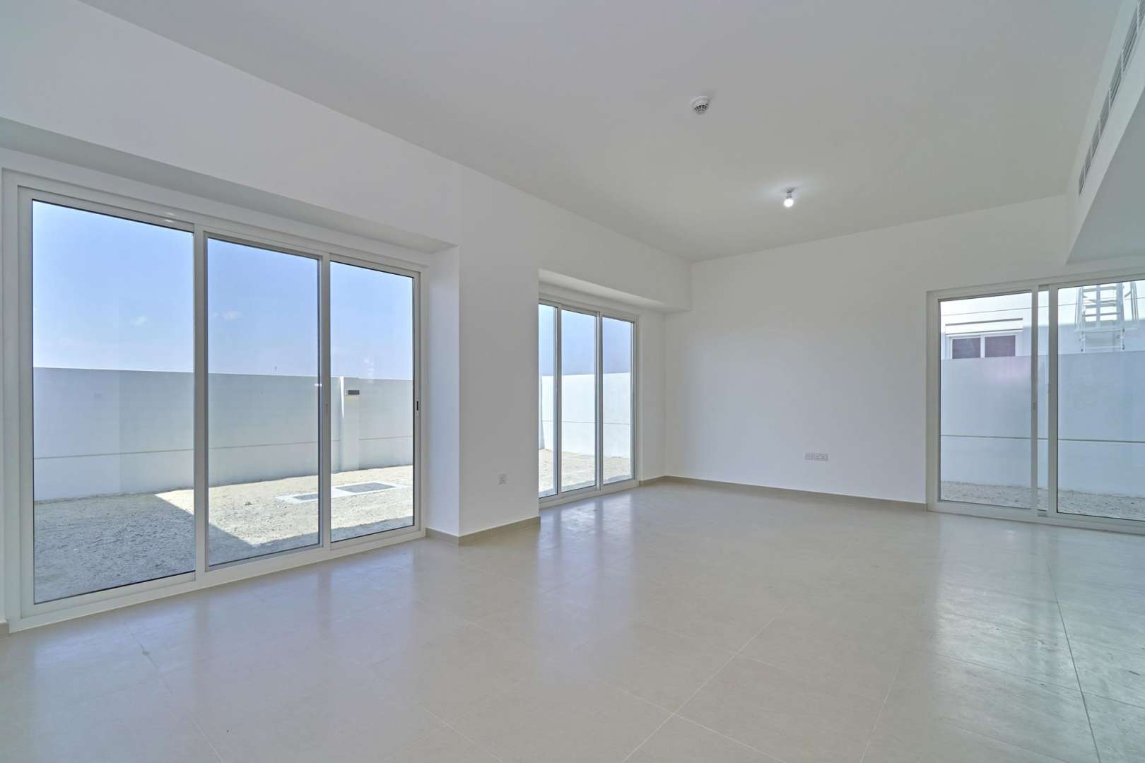 Spacious living area in Arabella Townhouses, Mudon; modern design, large windows, tiled floors