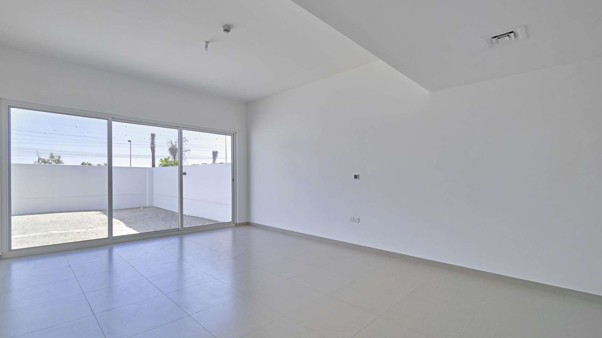 Bright living area in Arabella Townhouses, Mudon villa with sliding glass doors to patio