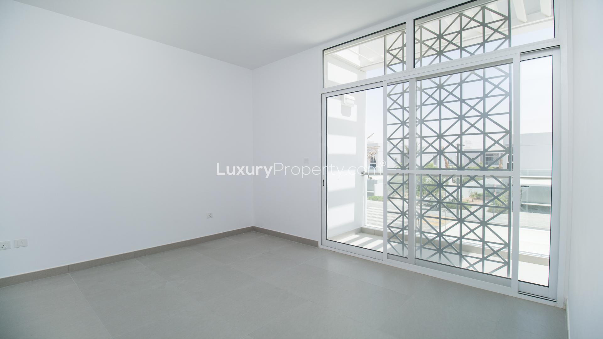 "Modern Type A townhouse exterior in Arabella, Mudon, featuring unique architectural design.",Bright bedroom with large windows in Arabella Townhouse, Mudon for sale