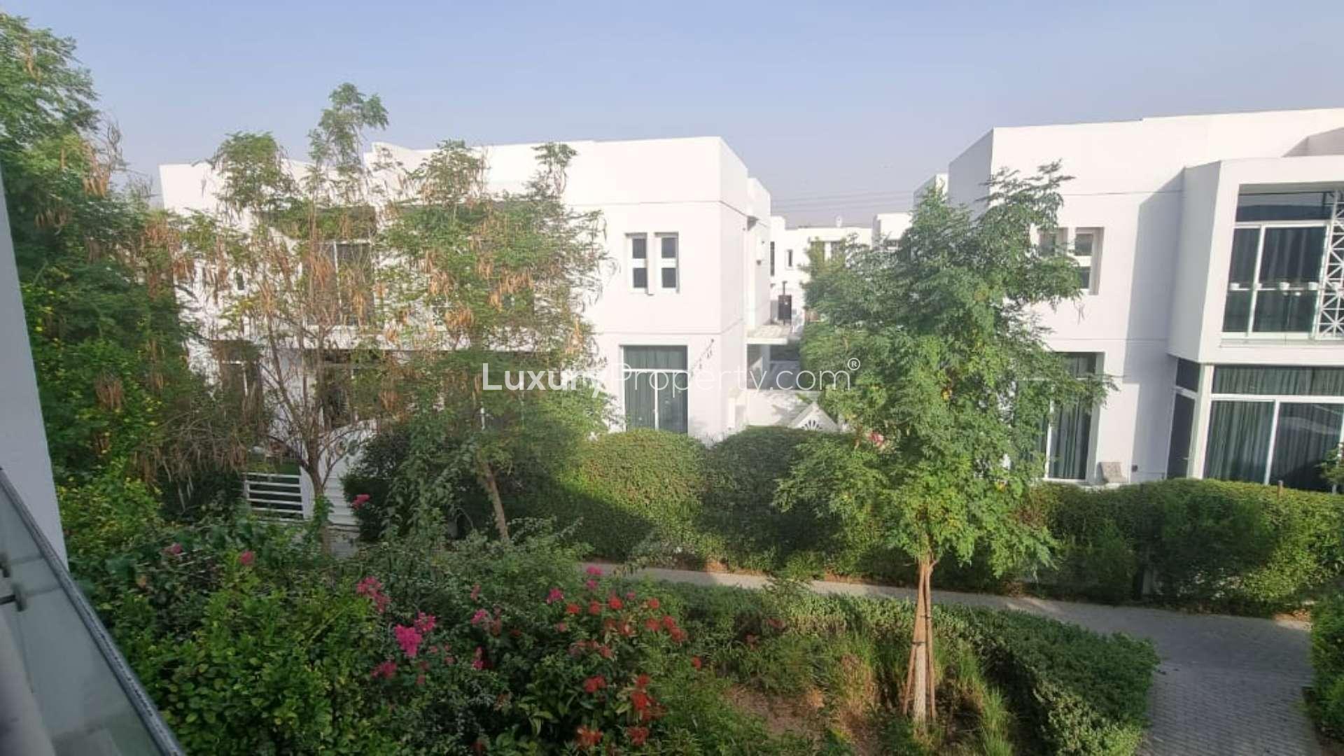 Garden view of Mudon Arabella townhouse with lush greenery and patio area