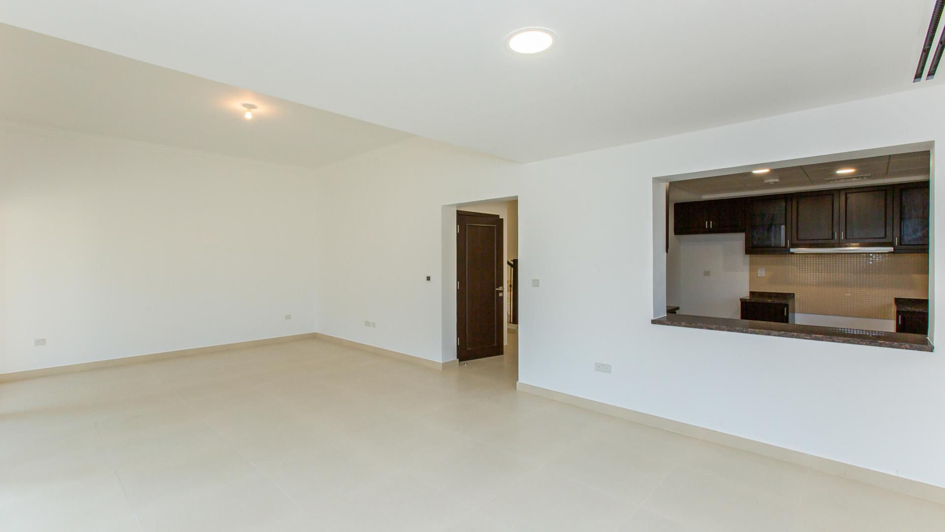 Bright living room in Casa Dora townhouse, Serena community, with large windows and tiled floor