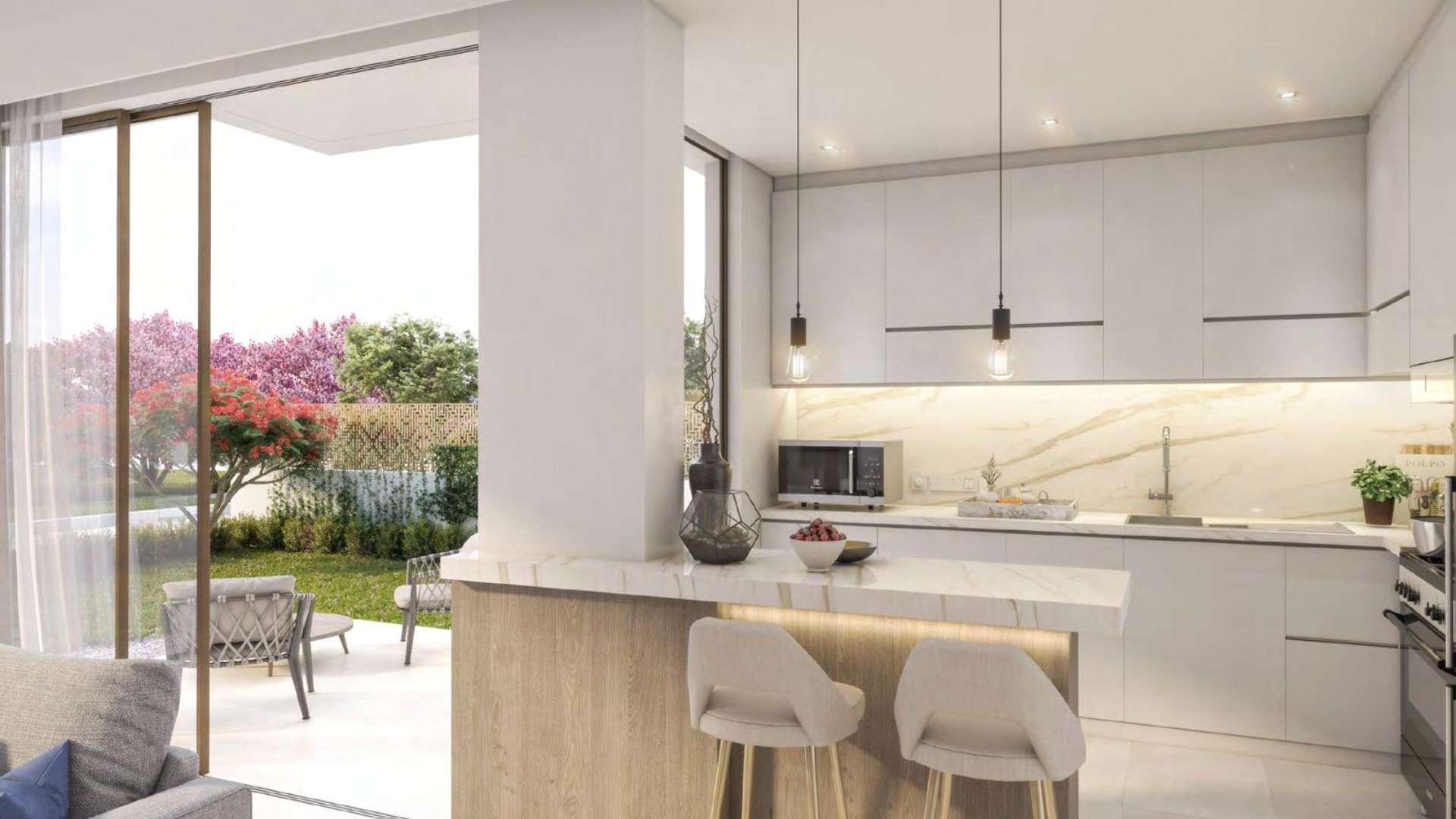 Modern open-plan living area in Cherrywoods townhouse, Dubai Land, with garden view