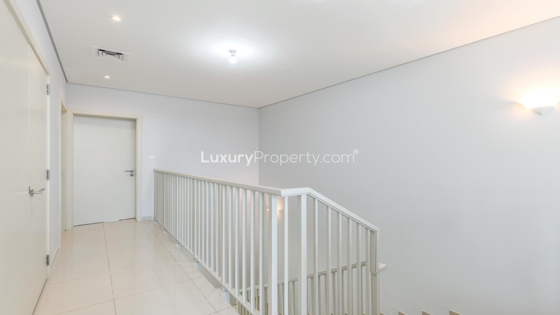 Modern dining and living area in Topanga townhouse, Damac Hills, with garden view