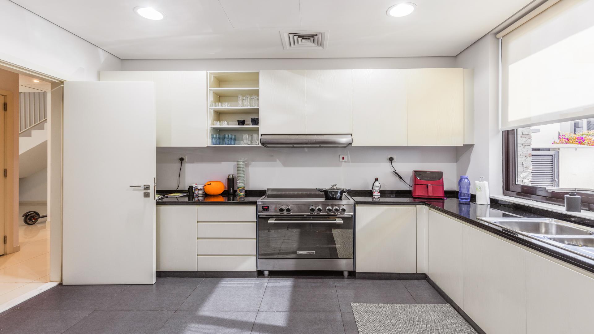 Modern kitchen in Topanga townhouse, Damac Hills, featuring sleek cabinetry and stainless steel appliances