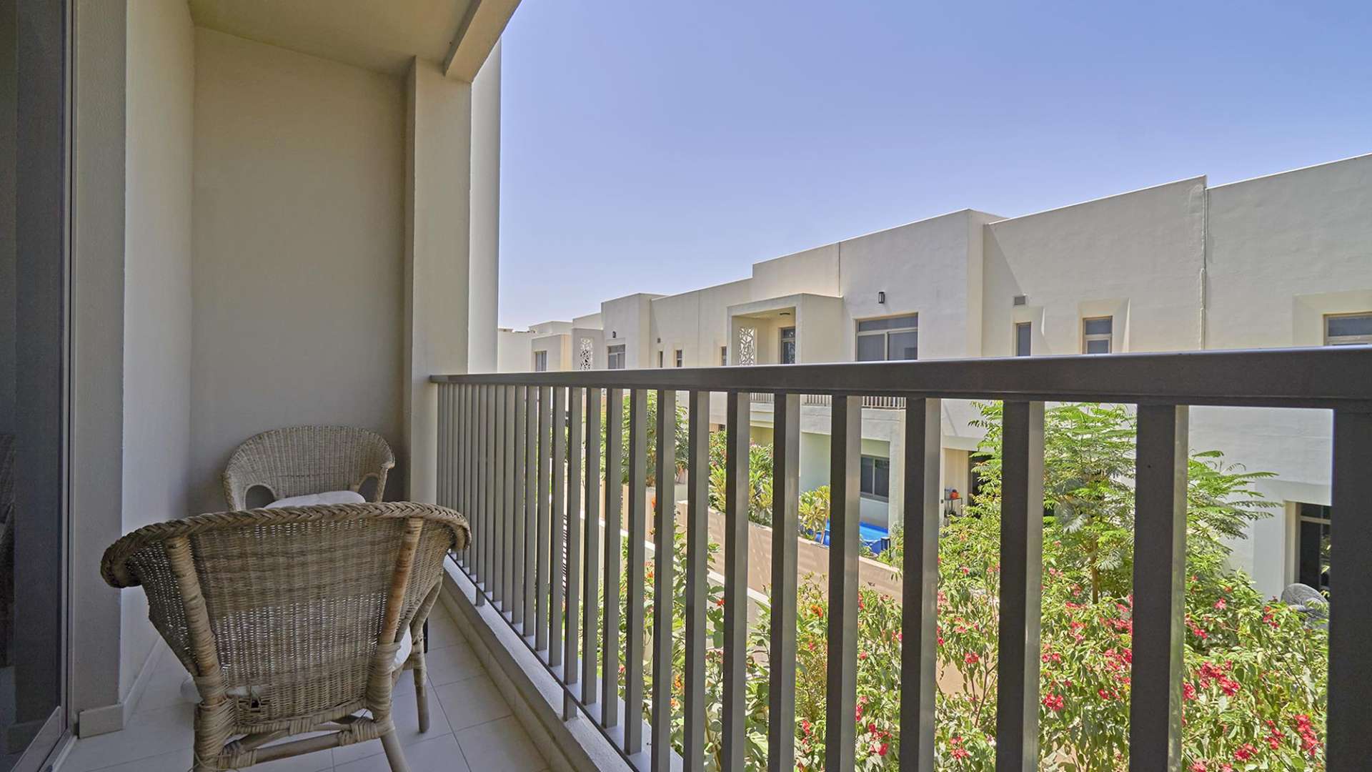"Modern exterior of 3-bedroom townhouse in Hayat Townhouses, Dubai, with carport and greenery.",Balcony view of Hayat Townhouses, Dubai, showcasing lush greenery and modern architecture
