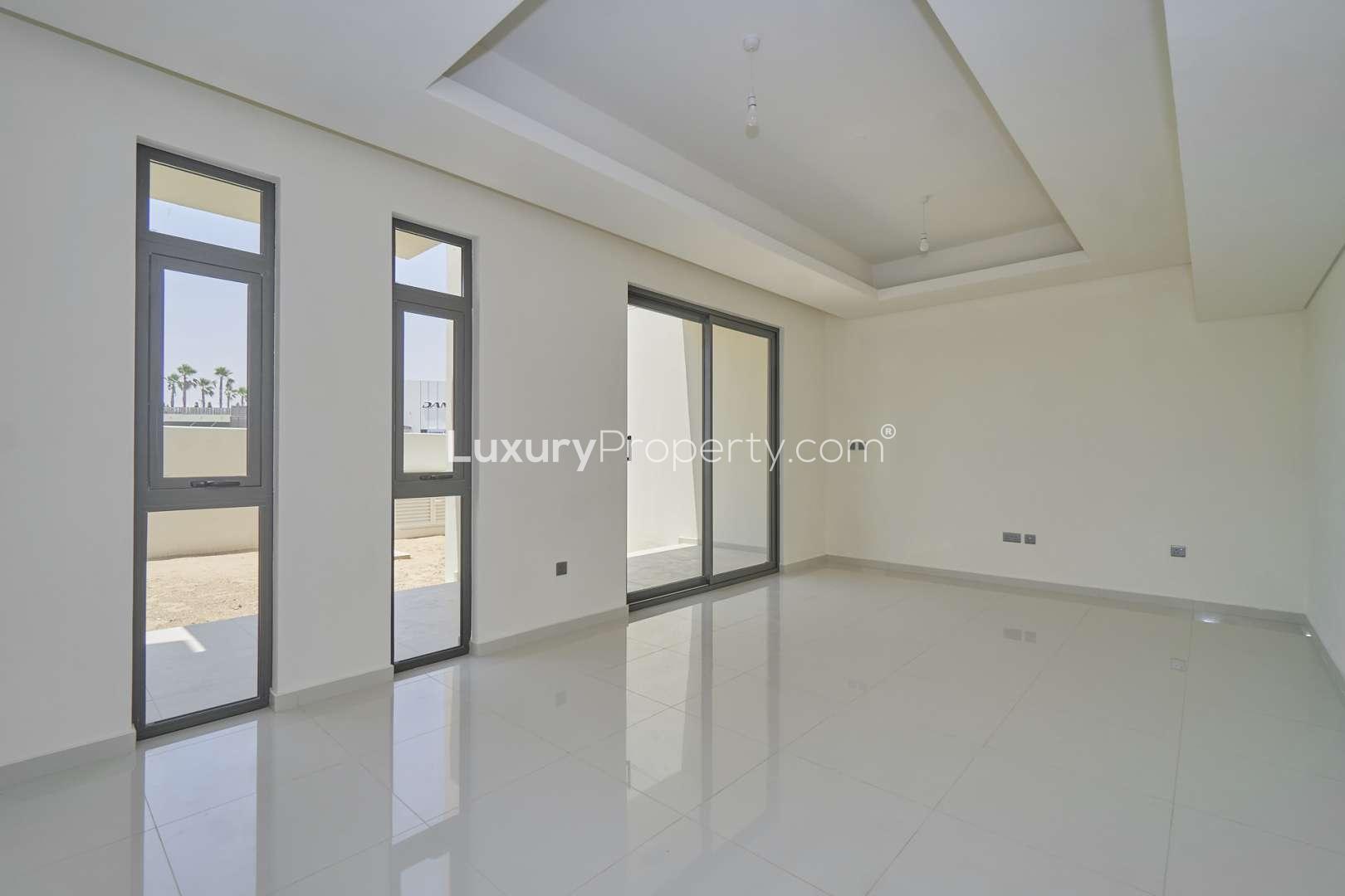 "Spacious living area with large windows in Juniper townhouse, Damac Hills 2 for sale.",Bright living room in three-bedroom townhouse, Juniper, Damac Hills 2, for sale