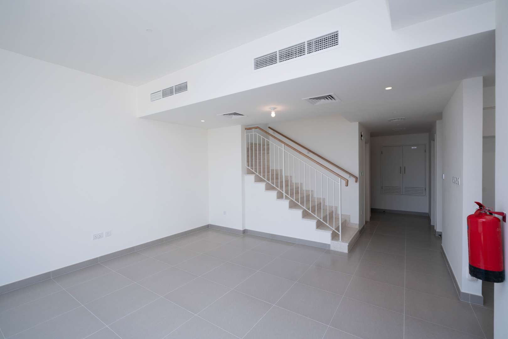 Modern living area in 3-bedroom townhouse, Maple, Dubai Hills Estate, with staircase and large window