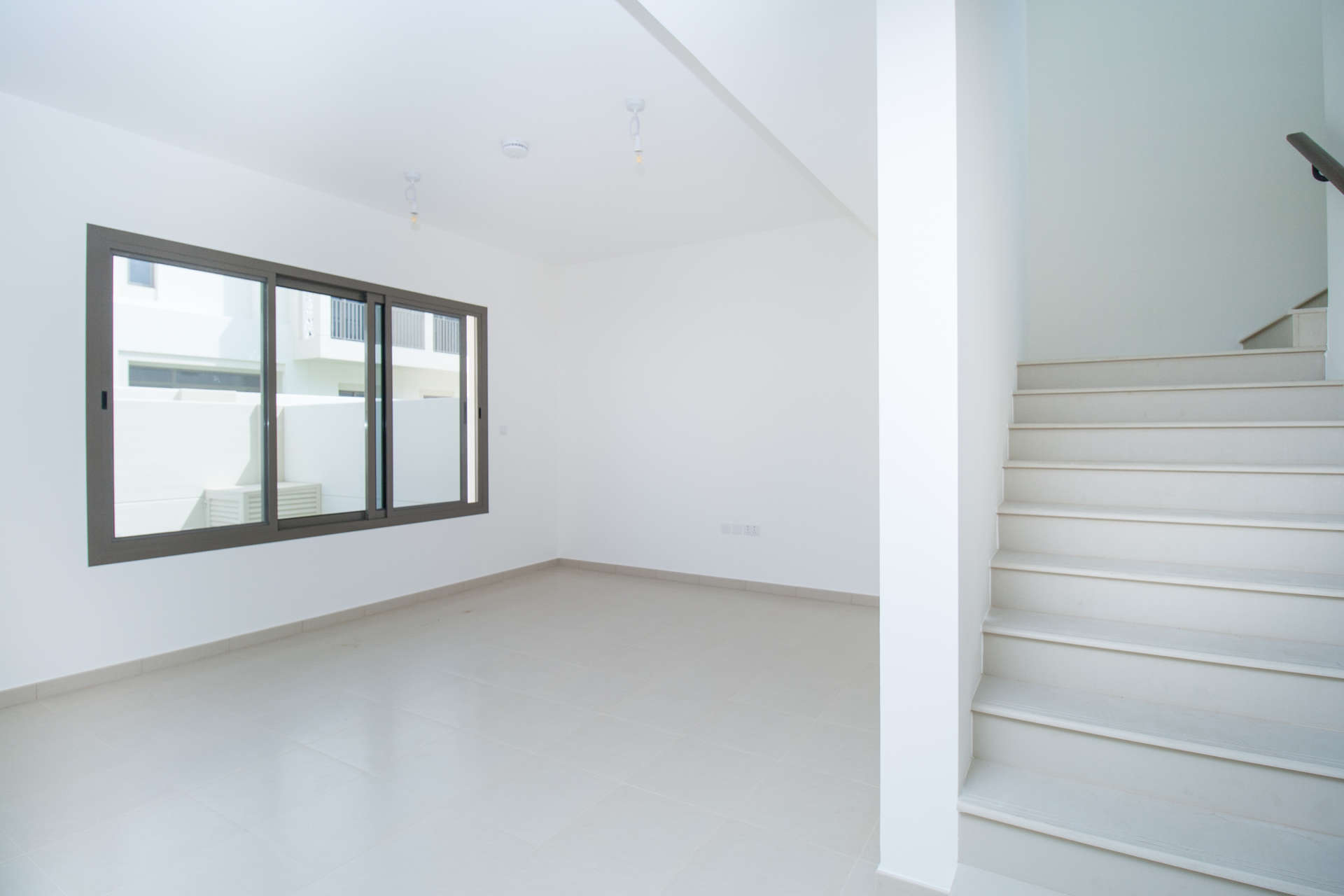 Modern living area in 3-bedroom townhouse, Noor Town Square Dubai, with sliding doors and stairs