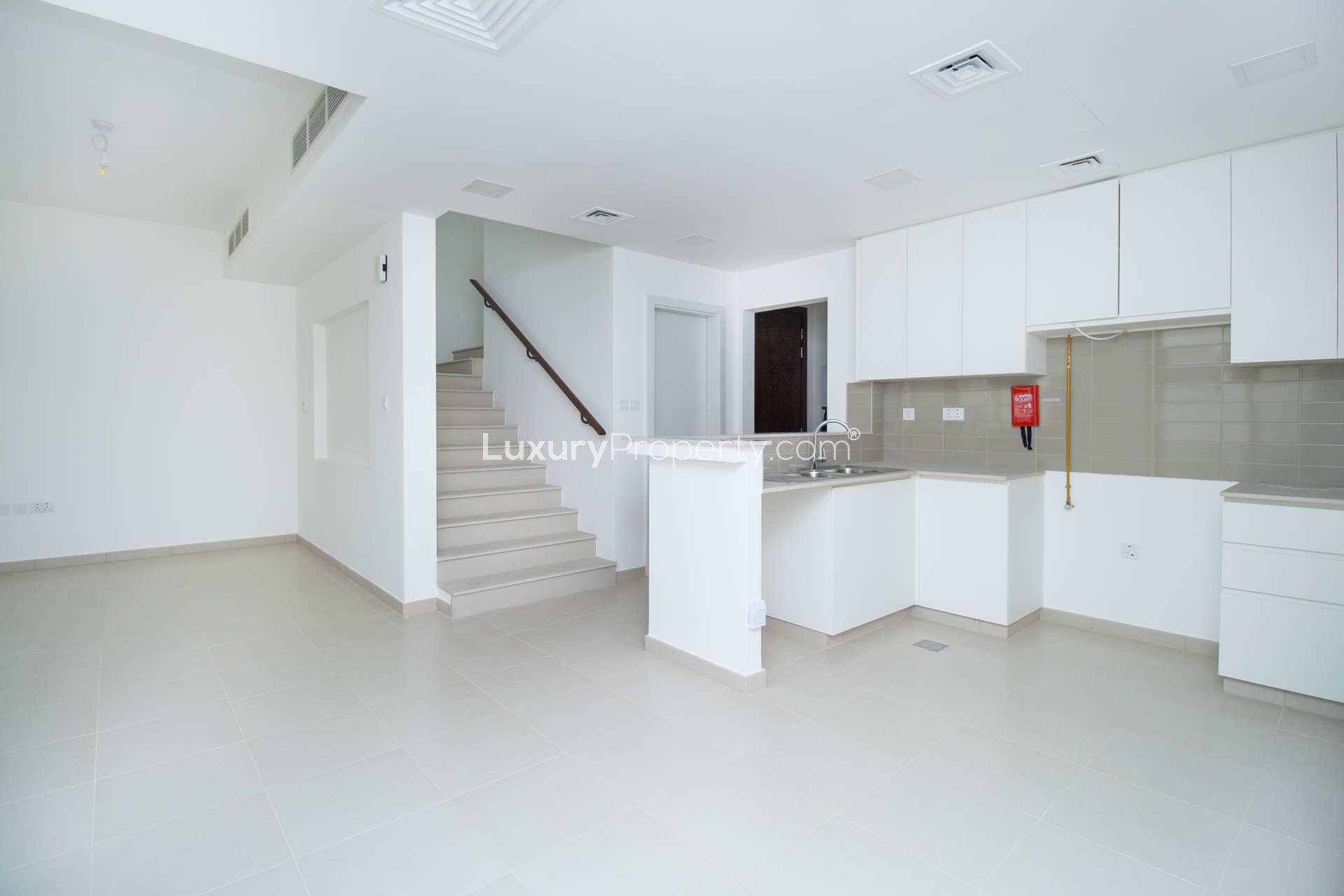 Exterior view of modern 3-bedroom townhouse in Noor, Town Square Dubai, with patio area