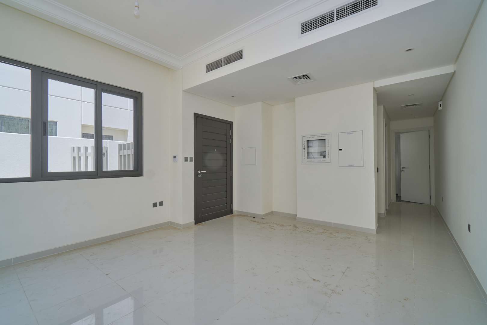 "Bright living room in Primrose townhouse, Damac Hills 2, with large windows and modern design.",Bright interior of a three-bedroom townhouse in Primrose, Damac Hills 2, for sale