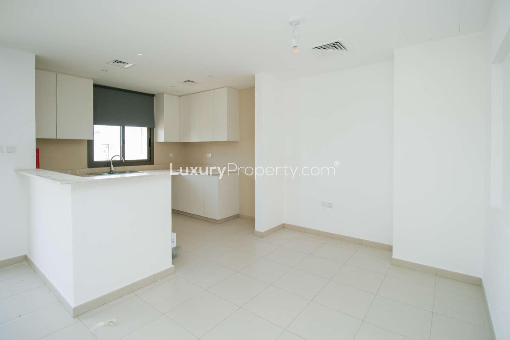 Bright living area in Safi Townhouses, Town Square, featuring large windows and open layout