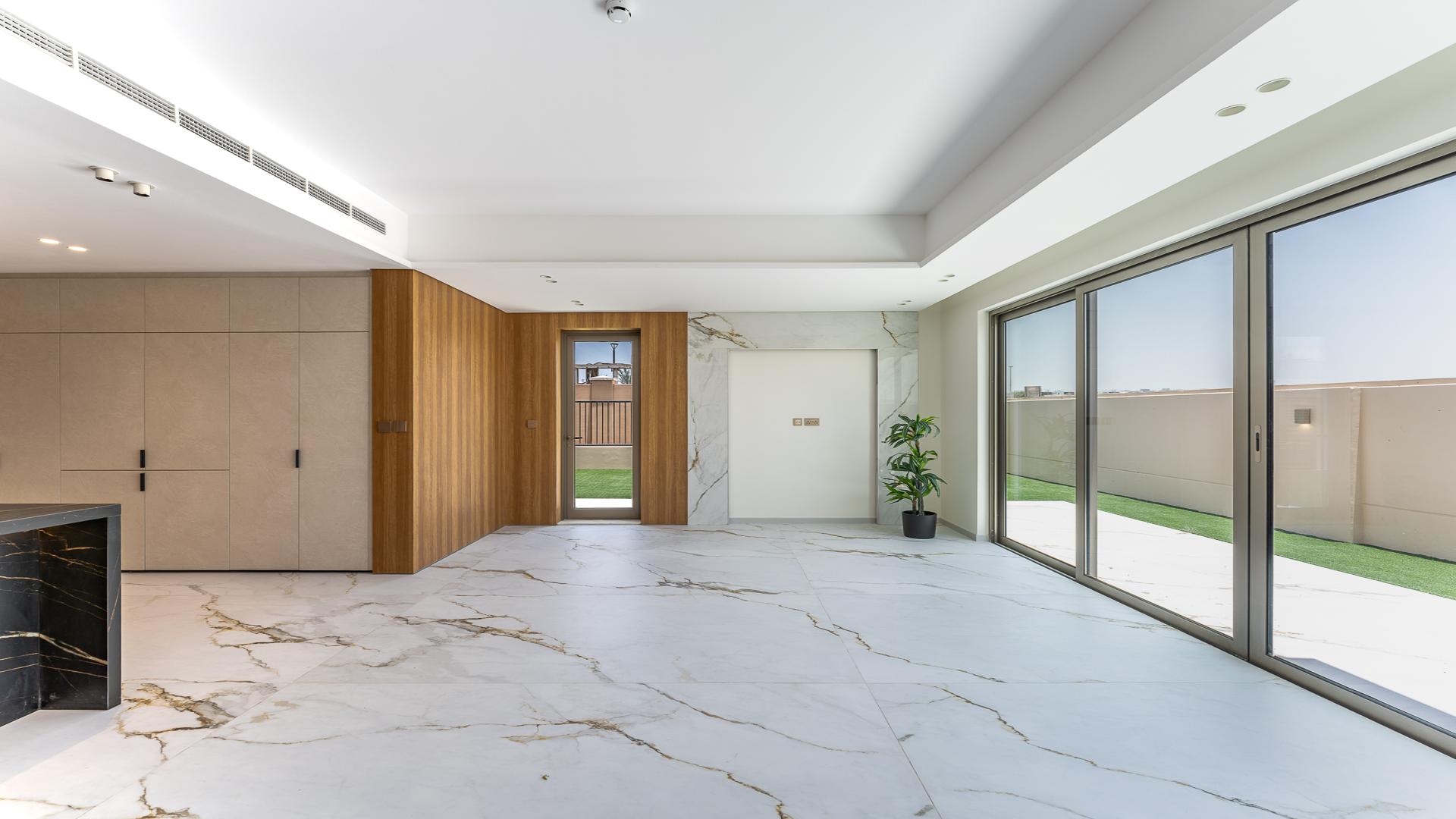 "Elegant corner townhouse patio with glass doors, Jumeirah Golf Estates, lush garden view.","Spacious living area in elegant 3-bedroom townhouse, Jumeirah Golf Estates, Jasmine Lane.",Modern kitchen with marble floors in Jumeirah Golf Estates townhouse, Jasmine Lane